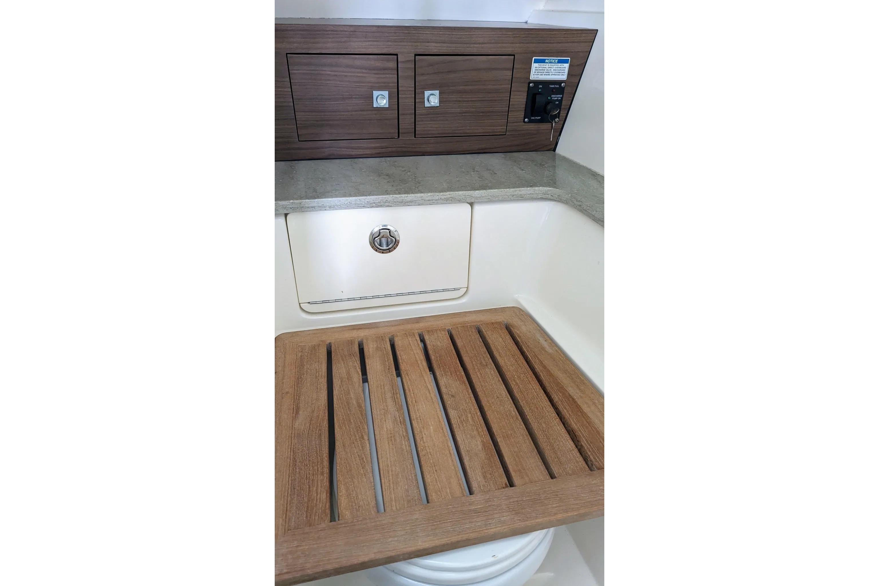 Interior of 2017 Boston Whaler 320 Vantage boat with wooden accents and storage compartments.