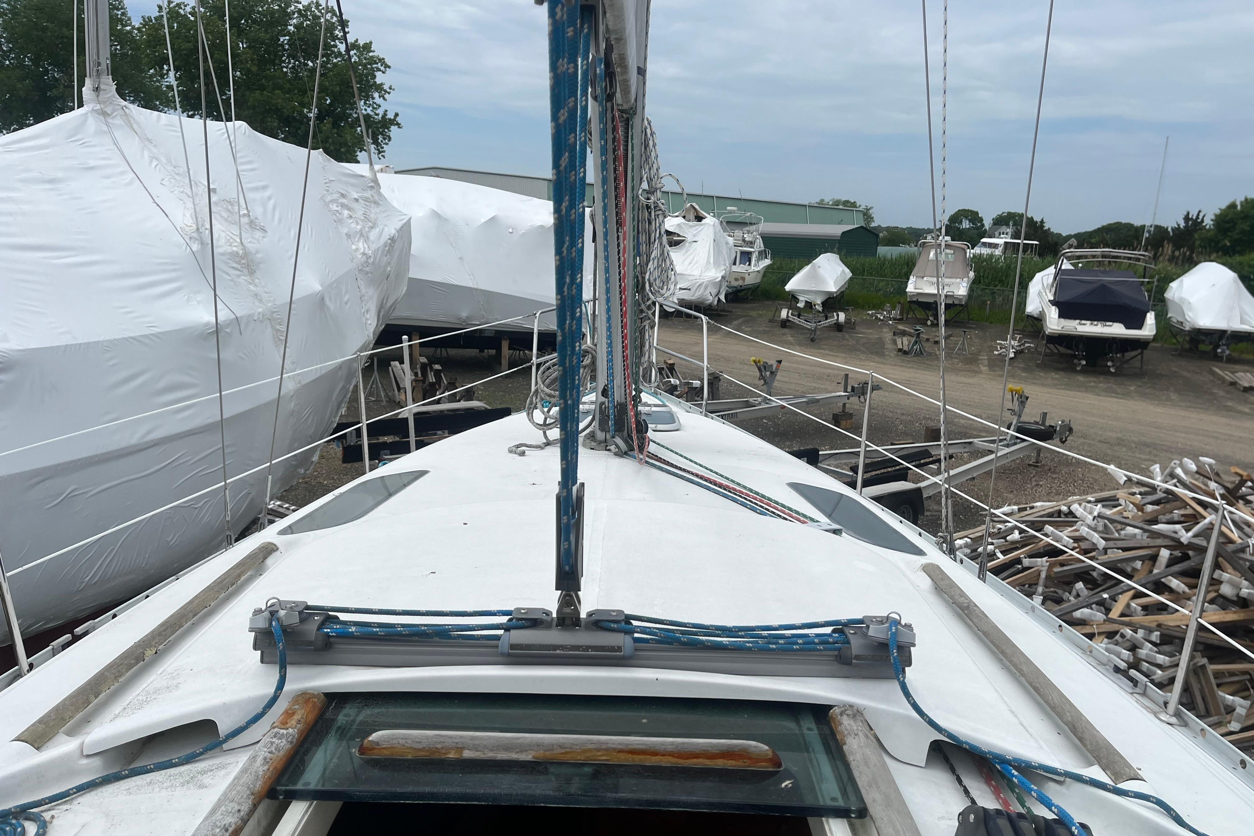Beneteau Oceanis 321 sailboat, 1999 model, docked with other covered boats in a marina.