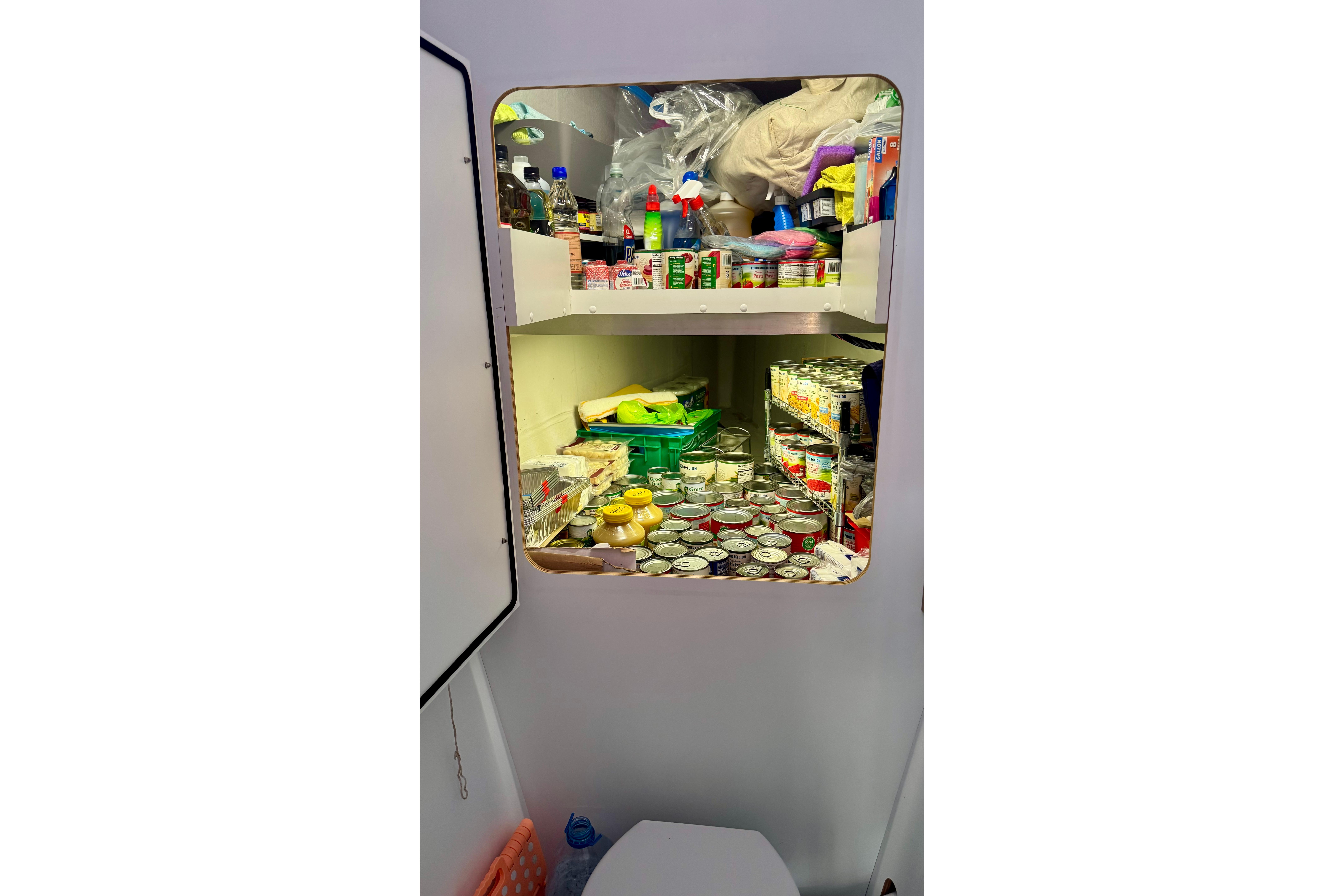 Pantry storage on 2020 Fountaine Pajot Saona 47 yacht, stocked with canned goods and supplies.