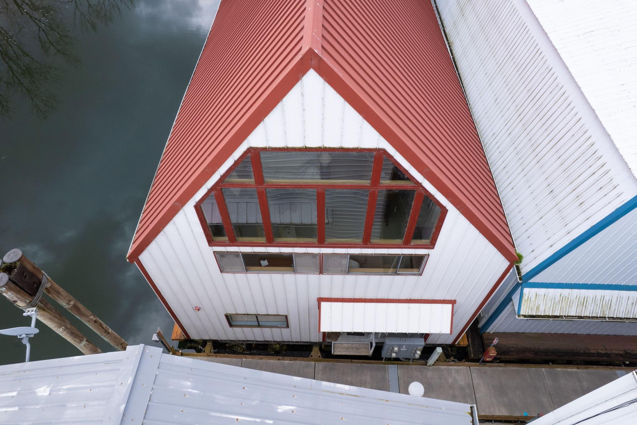 Aerial view of a 1976 custom boathouse with red roof and large windows.