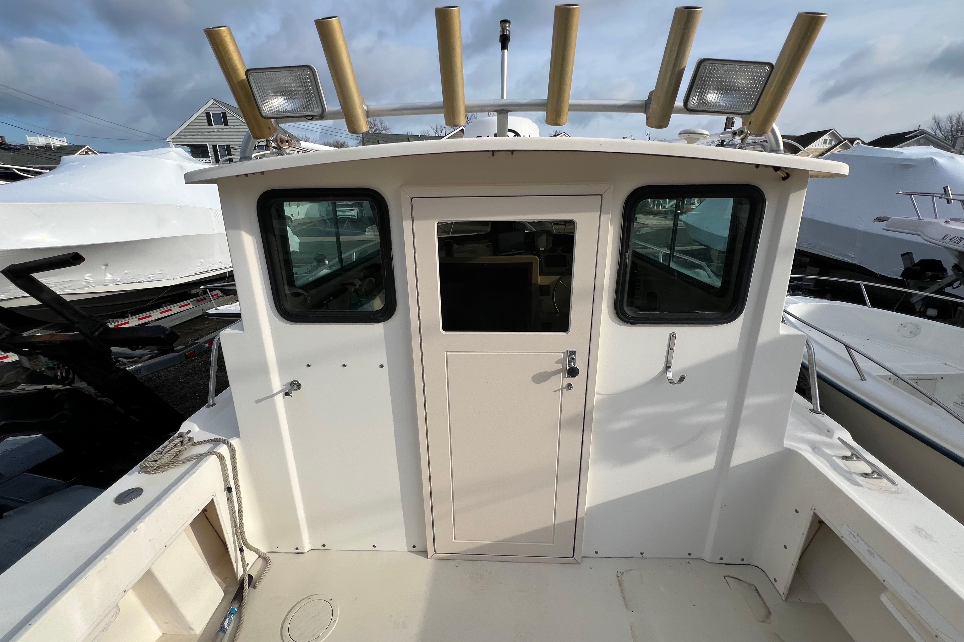 2001 Parker 2520 Deep Vee Sport Cabin boat with fishing rod holders and deck view.