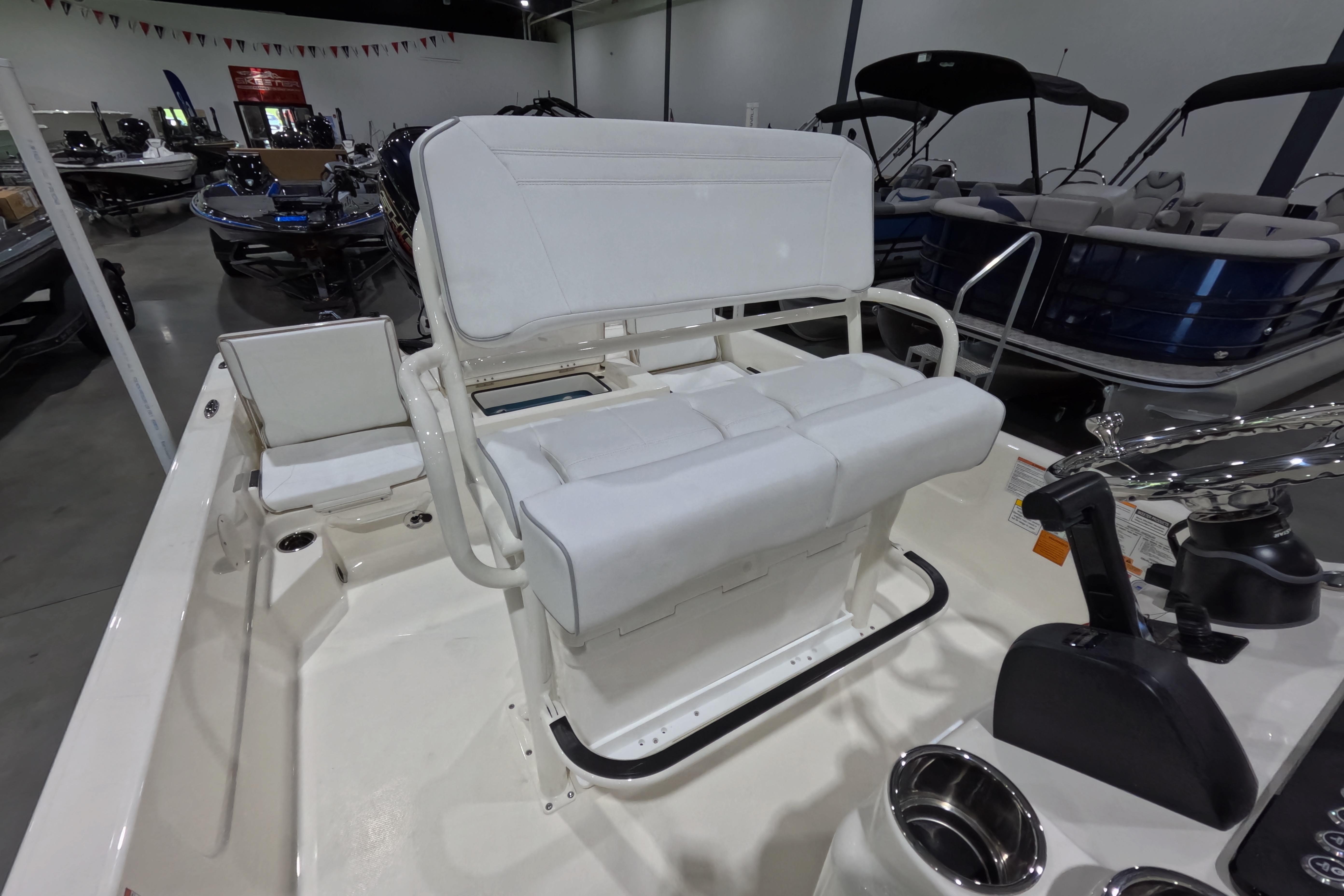 2026 Skeeter SX230 boat interior with white seating and modern design in showroom.