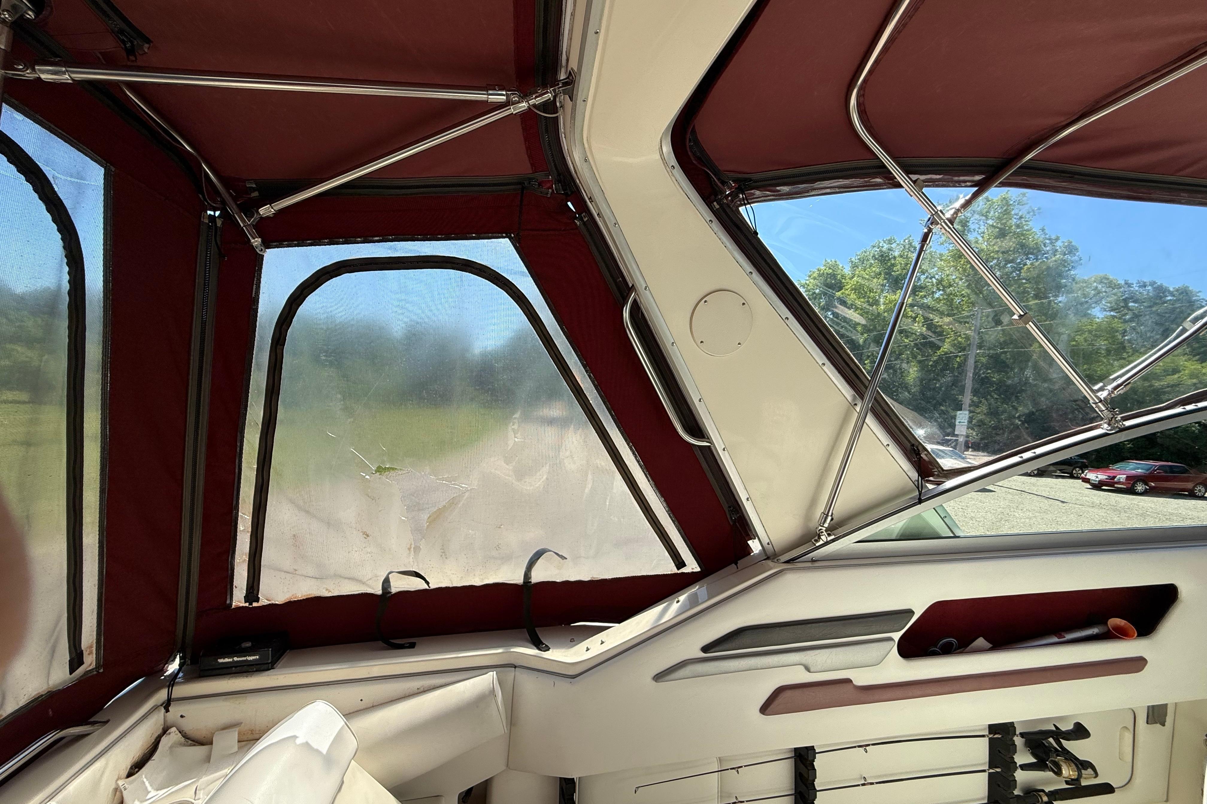 Interior view of a 1990 Sea Ray 310 Express Cruiser with red canopy and clear windows.