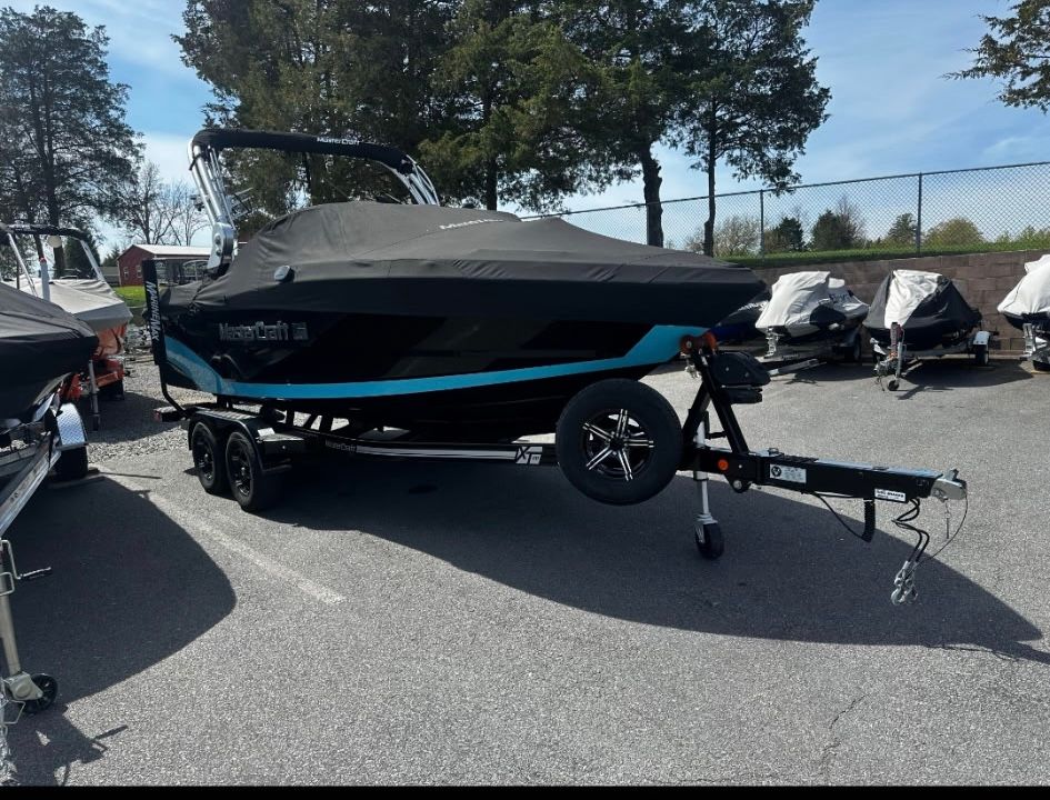 2019 MasterCraft XT boat on trailer, covered, parked outdoors.