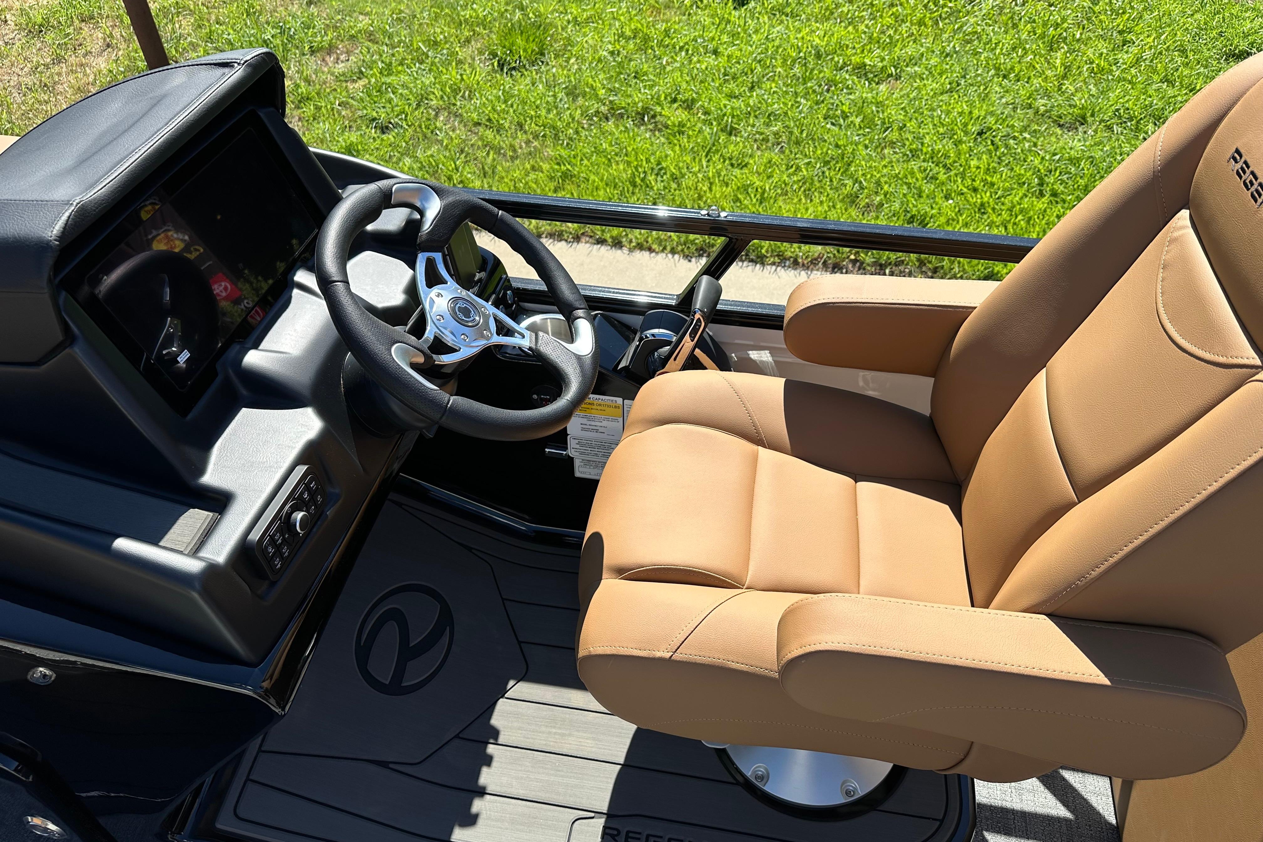 Luxurious captain's chair and steering console of 2026 Regency 230 DL boat.