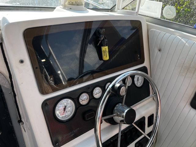 The image shows the helm of a 1998 Sport-Craft 252 Sport Fish boat with instruments.