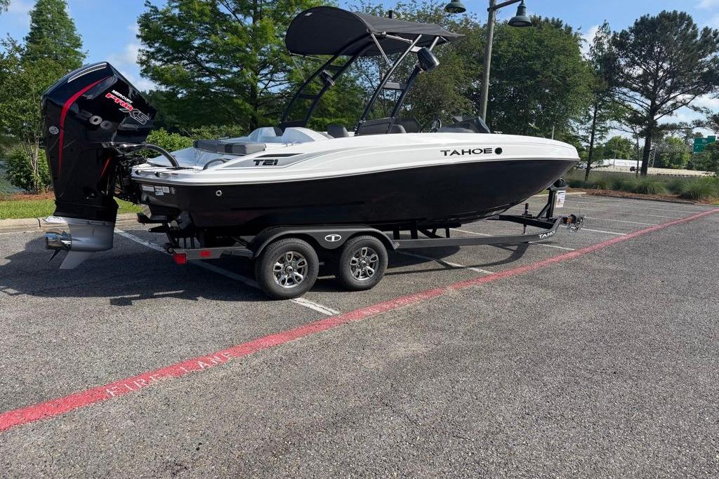 2026 Tahoe T21 boat on trailer in parking lot, surrounded by trees.