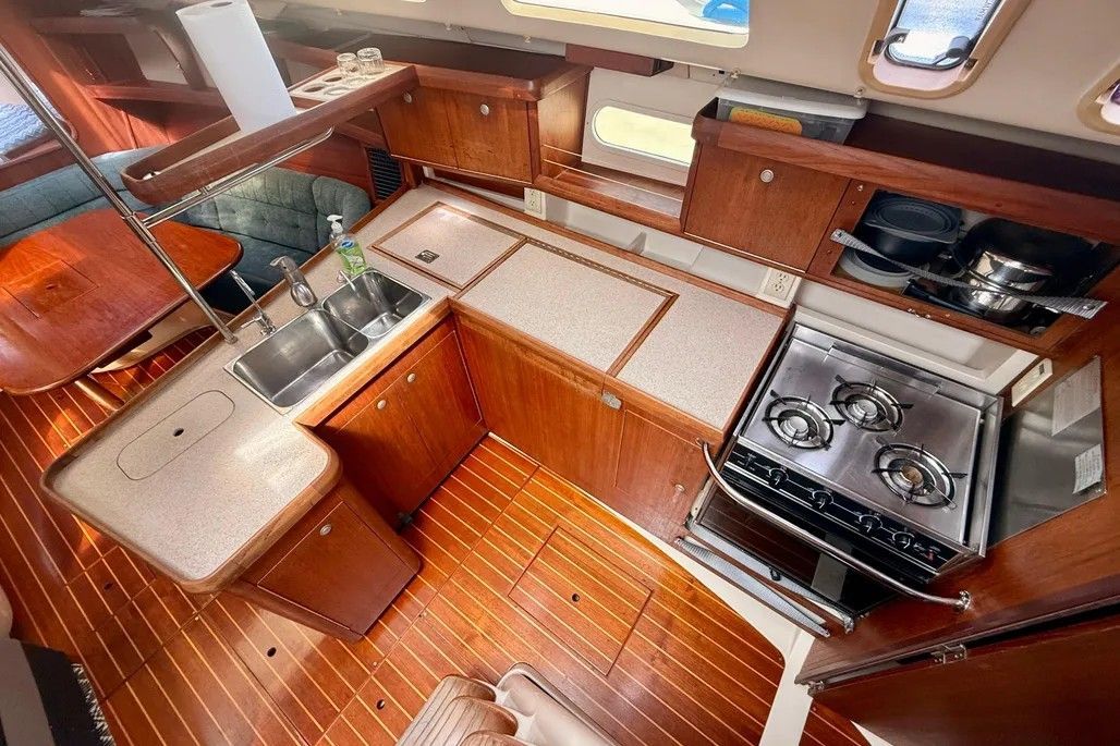 Interior of a 1996 Hunter 376 with kitchen, stove, and wood paneling.