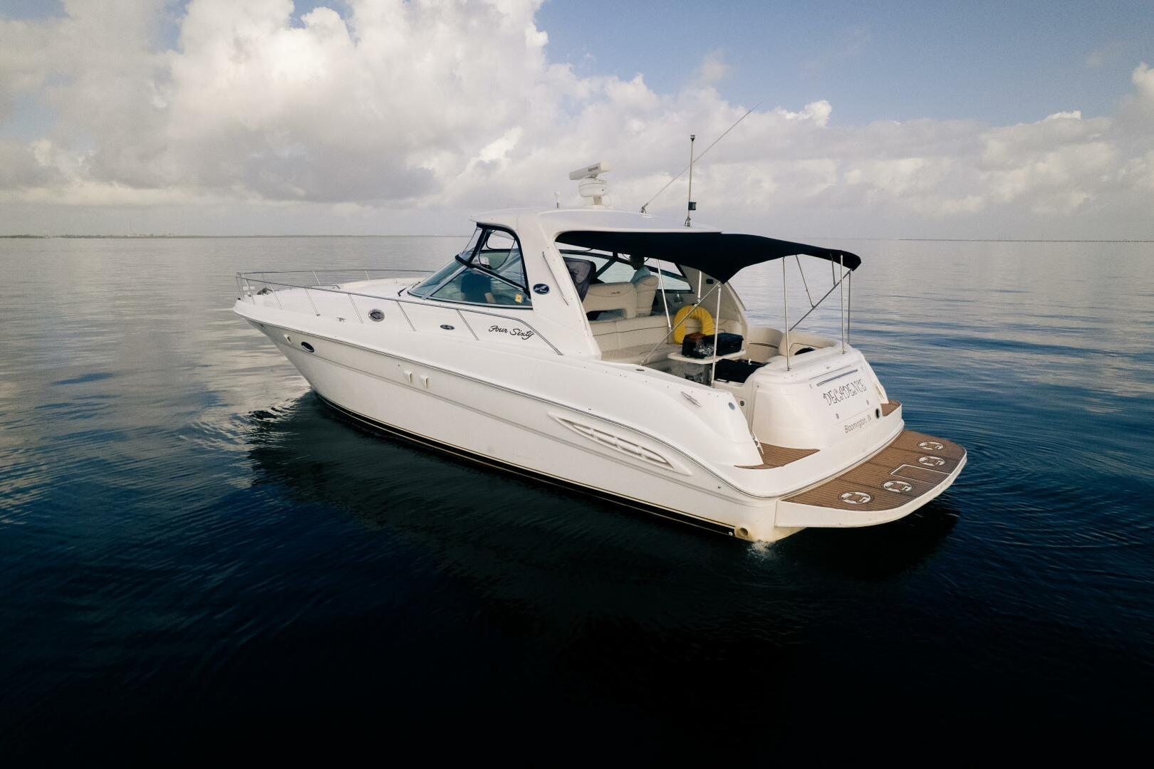 2003 Sea Ray Sundancer 460 yacht cruising on calm waters under a cloudy sky.