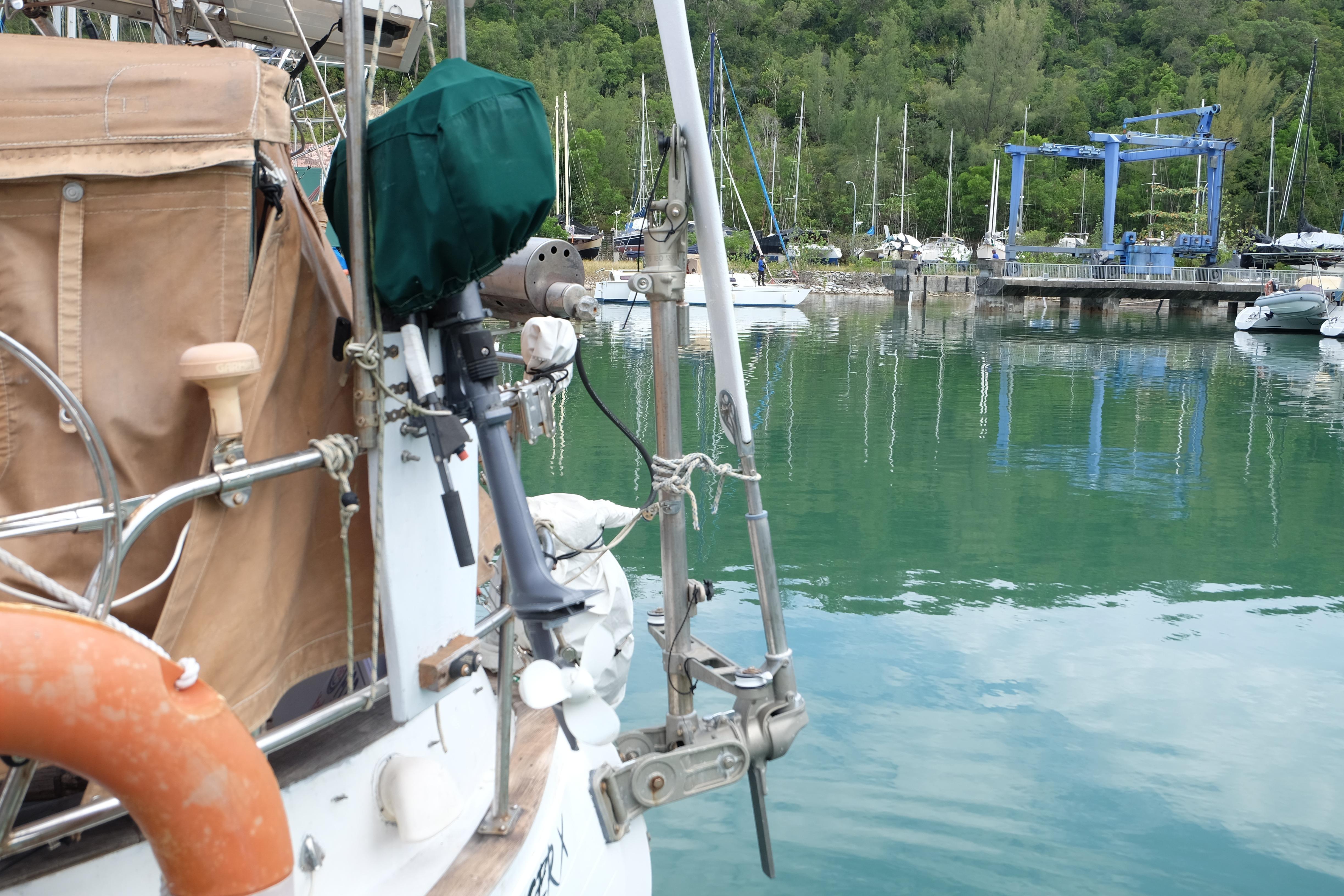 Sailboat docked in marina, Westwind 35 model, 1979, with lush green backdrop.