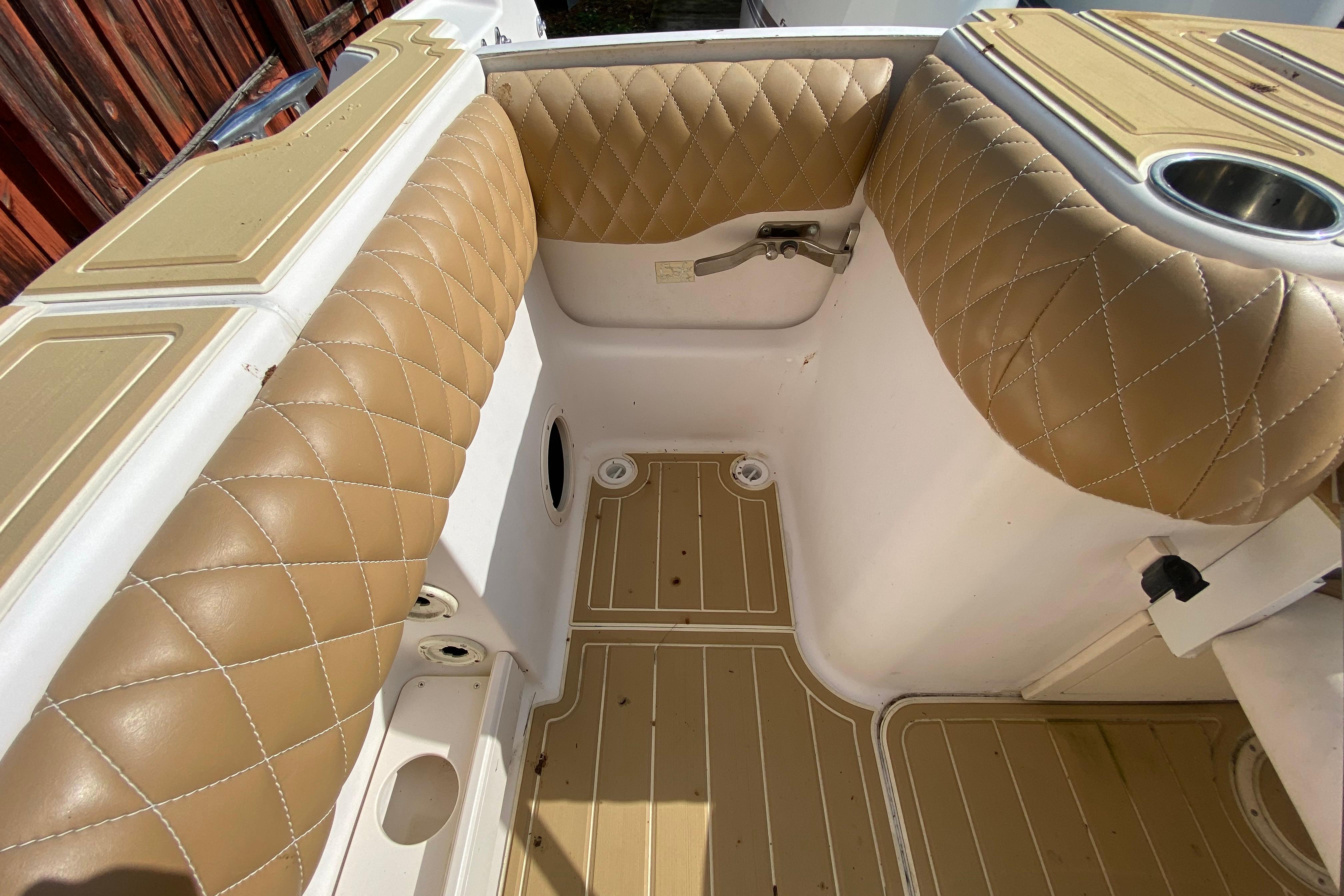 2004 Grady-White Canyon 283 boat interior with tan quilted seating and wood-patterned flooring.