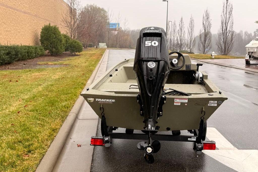 2026 Tracker Grizzly 1648 SC boat with Mercury 50 engine on trailer in rainy setting.
