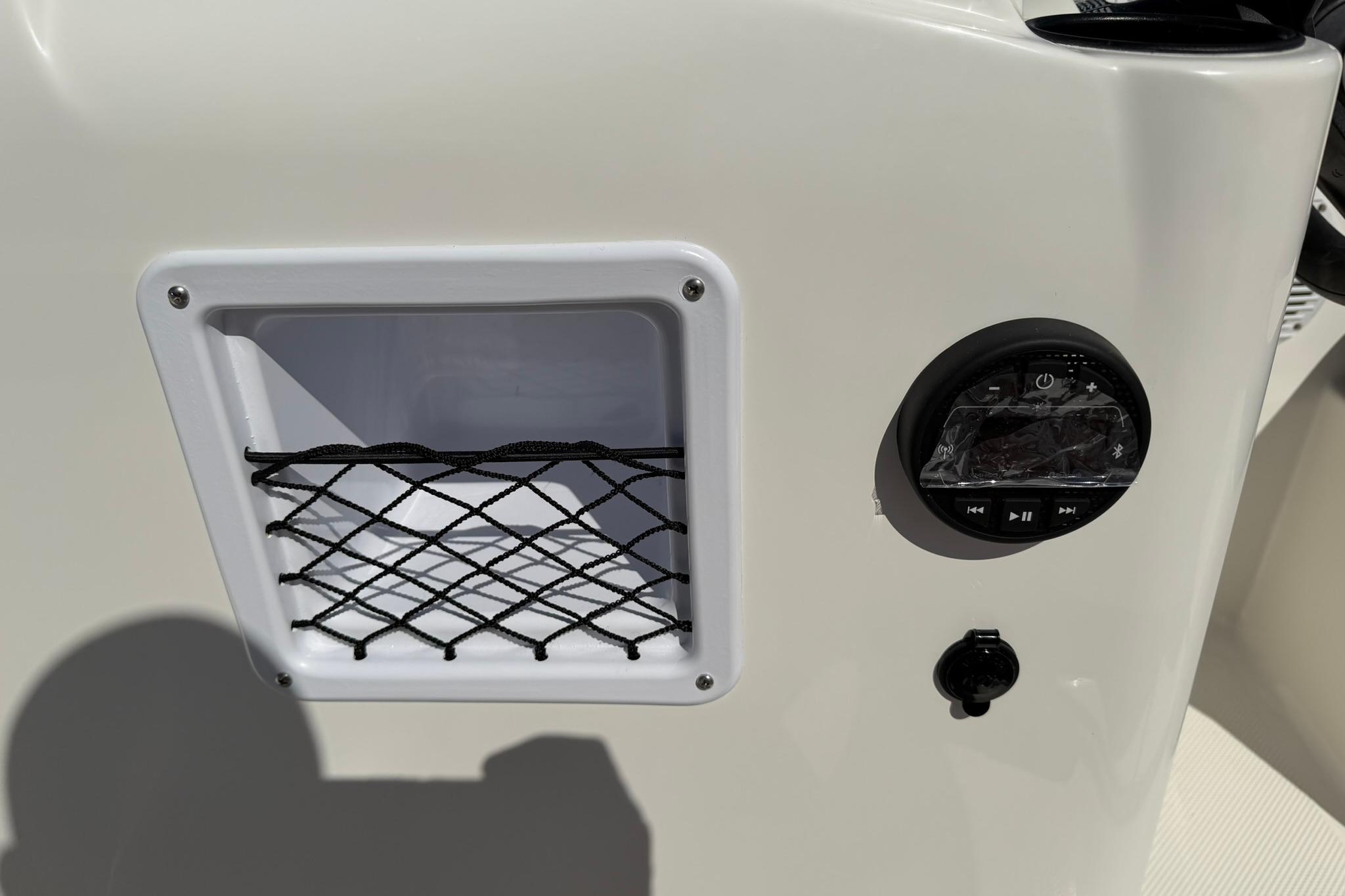 Control panel of 2026 Bayliner Element E18 boat with storage net and audio controls.