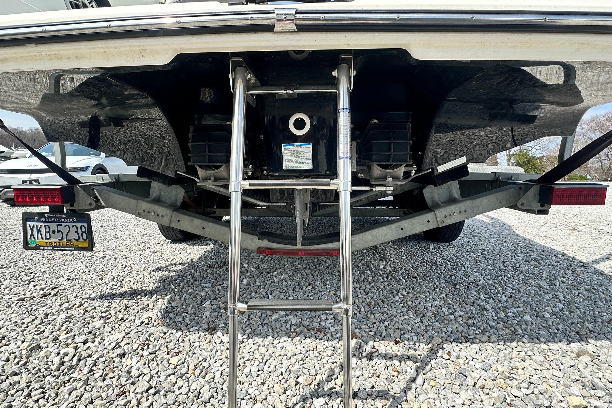 Rear view of a 2016 Yamaha 242 Limited S boat on a trailer with ladder.
