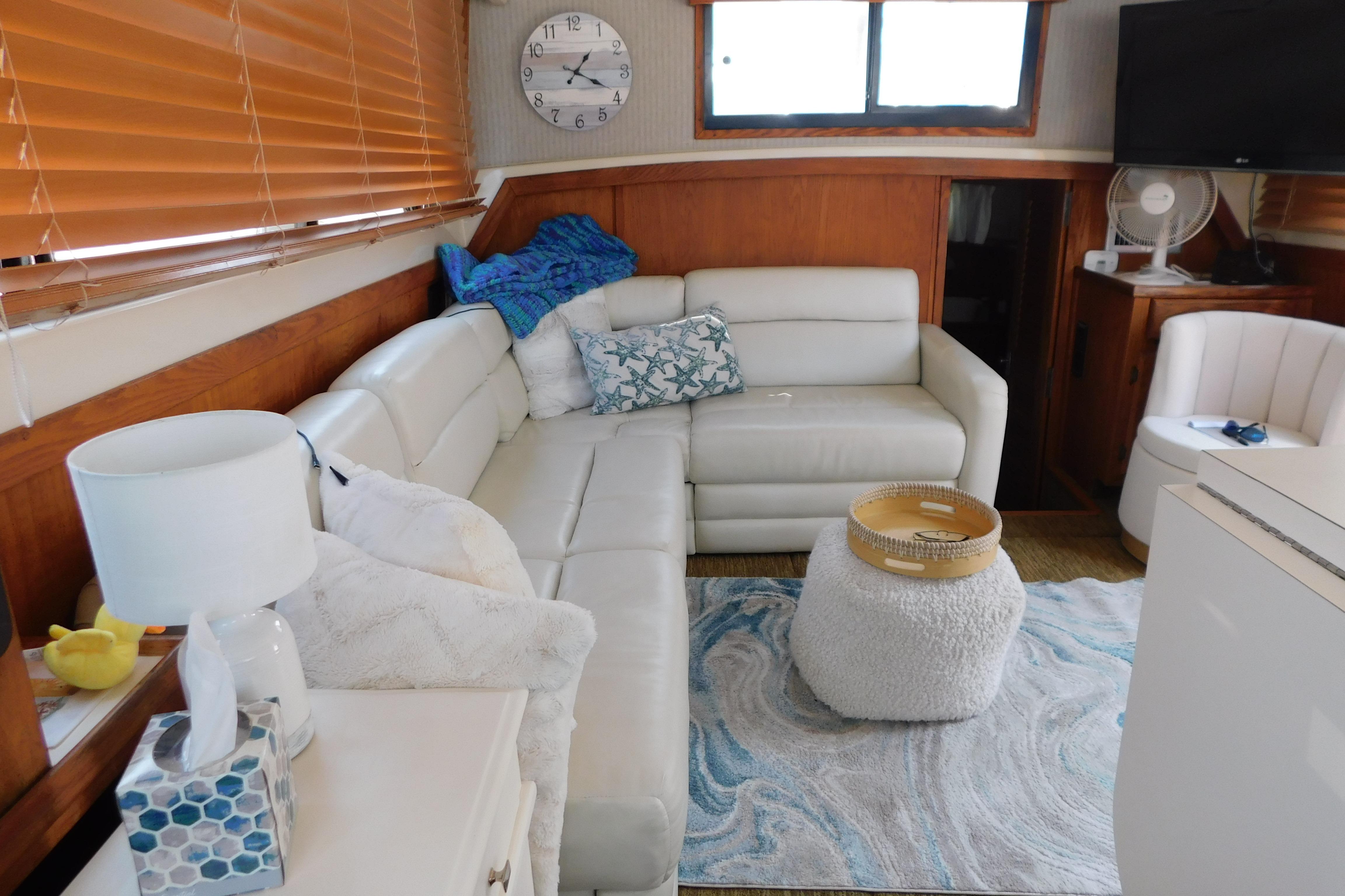 Cozy interior of 1987 Mainship 40 DC yacht with white leather seating and nautical decor.
