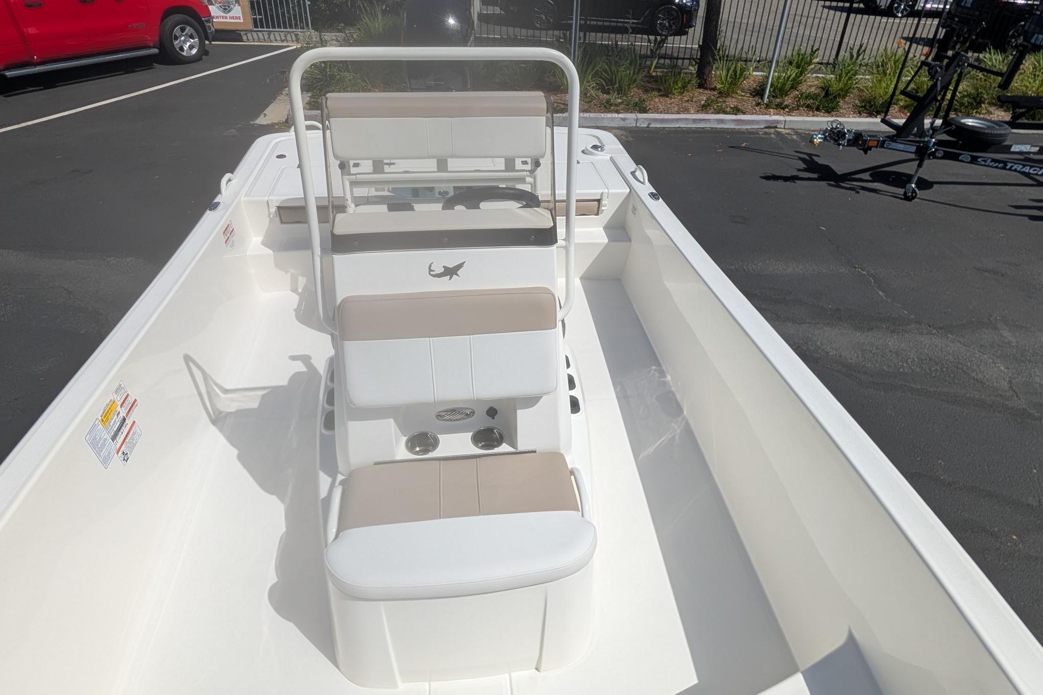 2026 Mako Pro Skiff 19 CC boat interior with seating and console, parked outdoors.