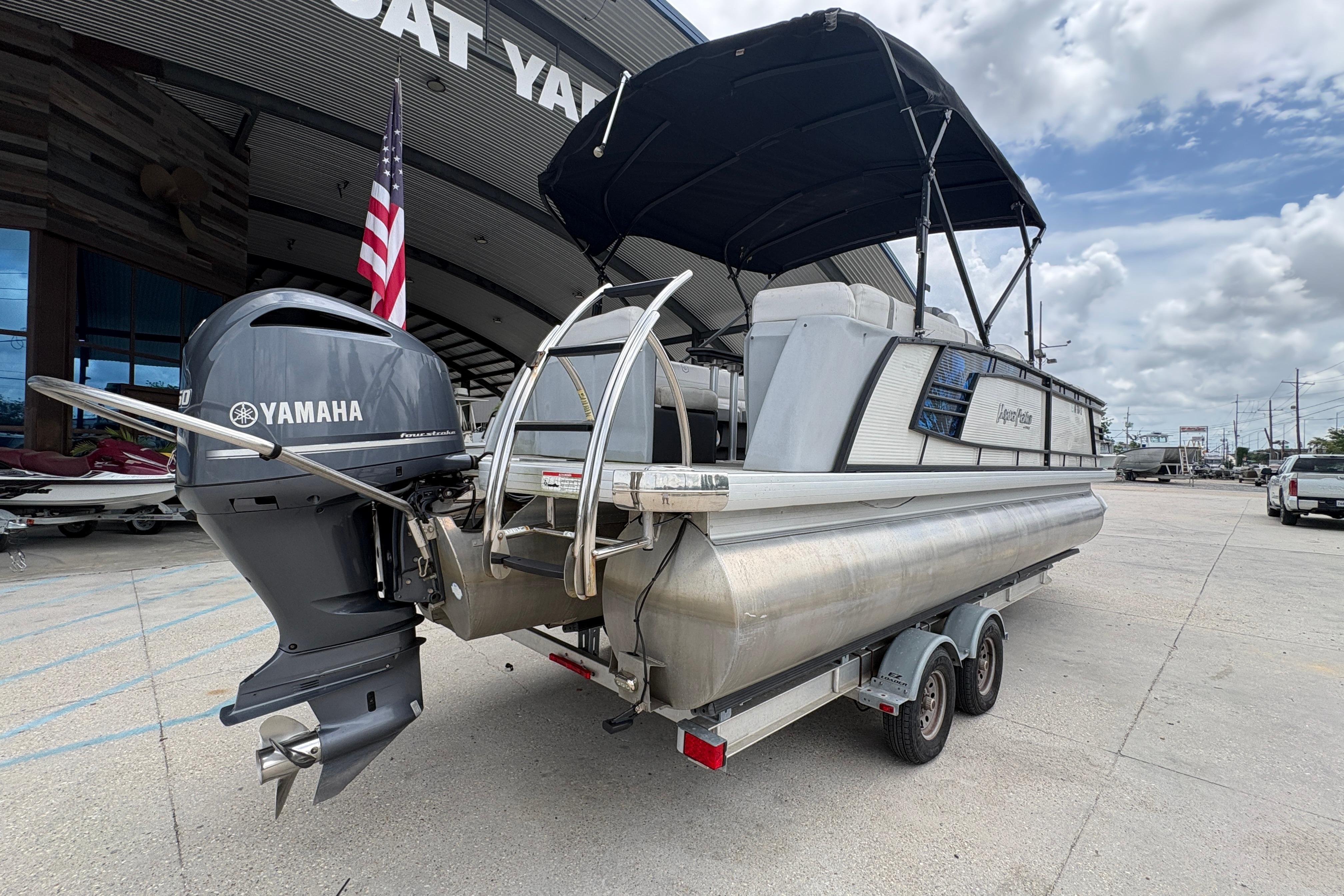 2019 Godfrey Aqua Patio pontoon boat with Yamaha motor, parked outside dealership.