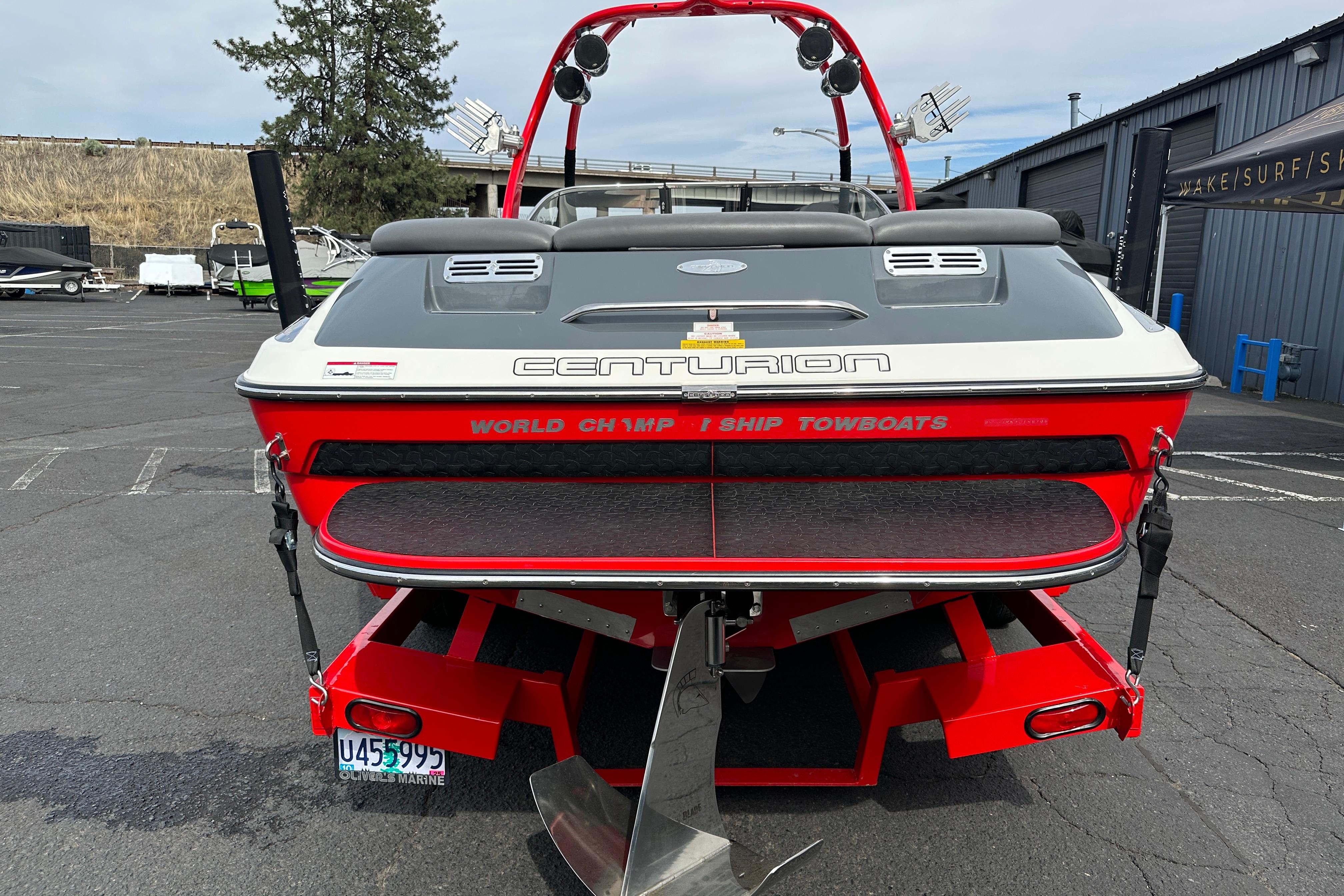 2008 Centurion Enzo SV240 boat, rear view, red and gray, parked outdoors.