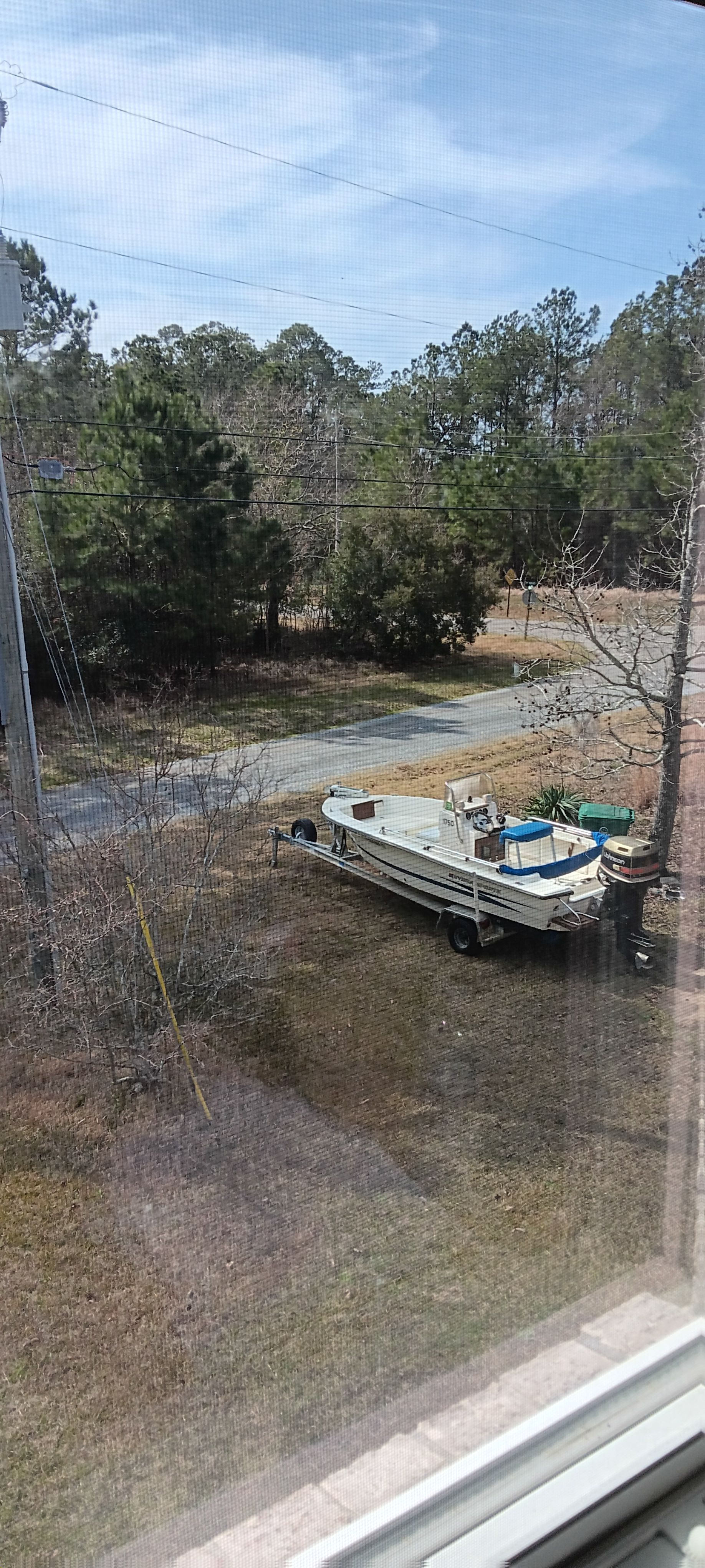 A 1990 Hydra-Sports Vector boat on a trailer in a grassy area.
