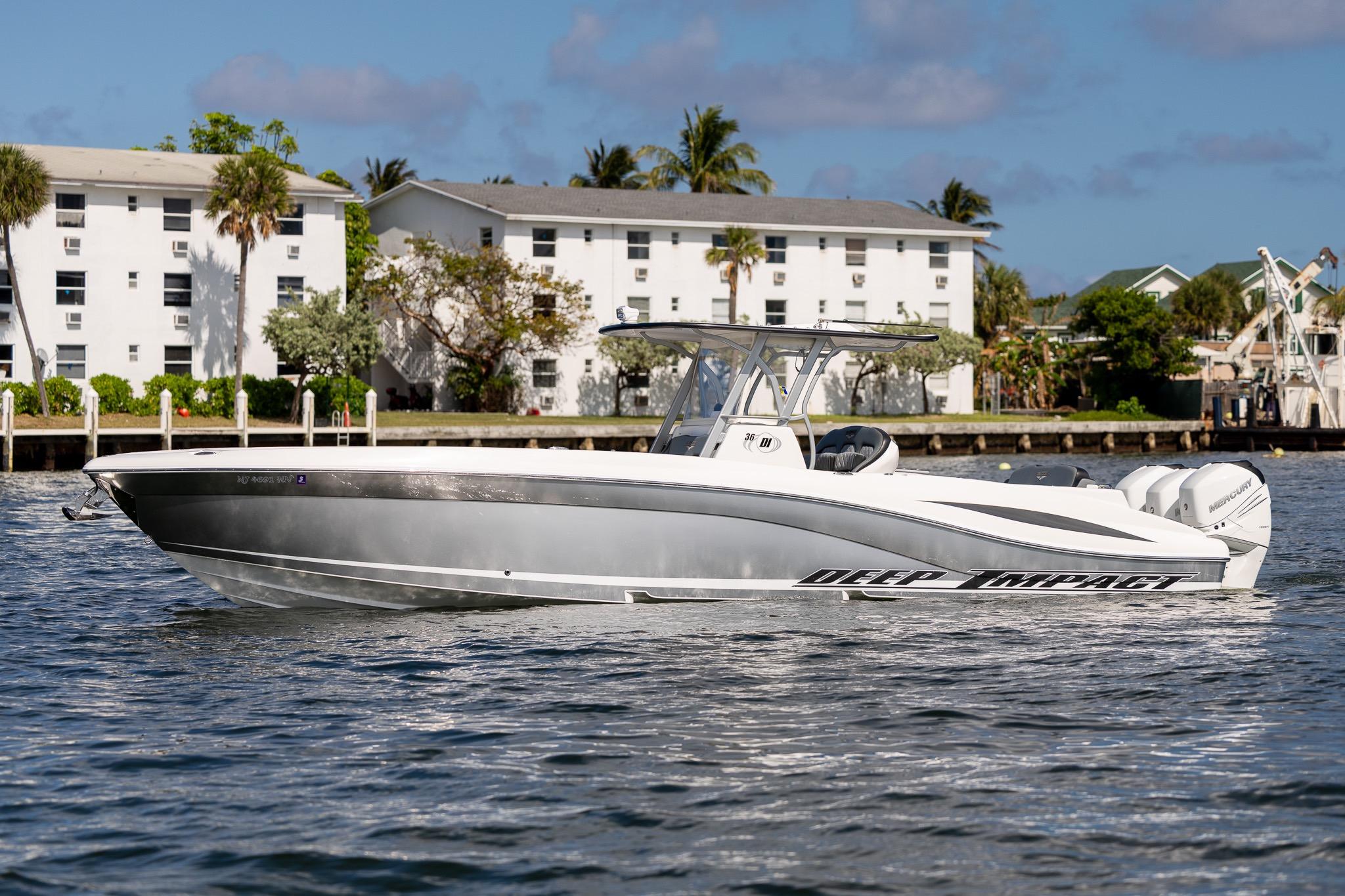 2019 Deep Impact 369 Sport boat on water, with buildings and palm trees in background.