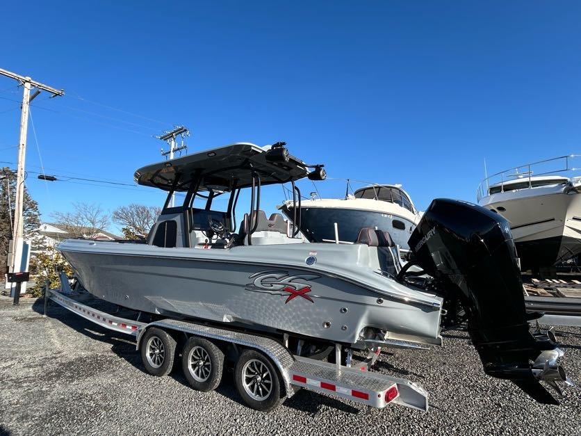 2024 Glasstream 32 GSX boat on trailer, parked outdoors under clear blue sky.