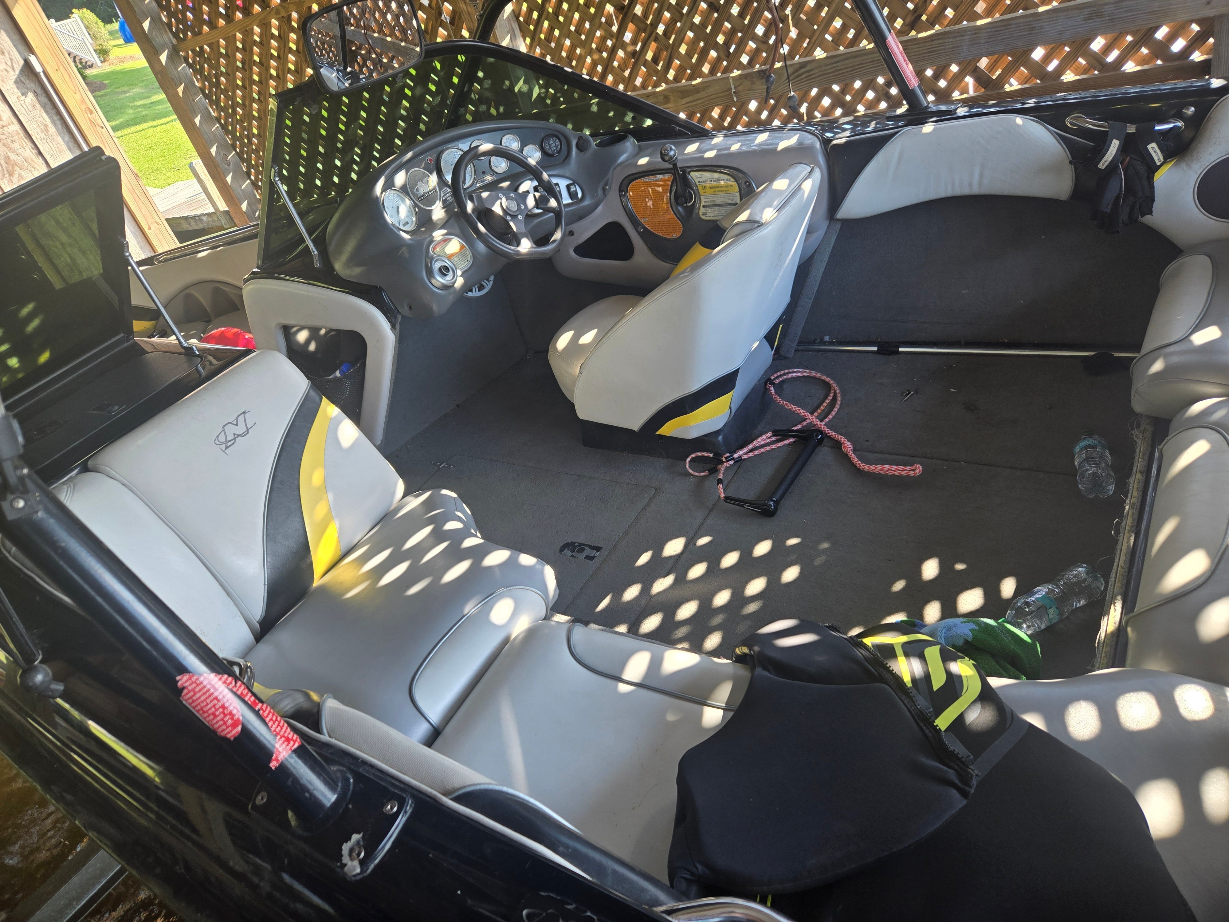 Interior of a 2003 Correct Craft Air Nautique with gray and yellow seating and a modern dashboard.