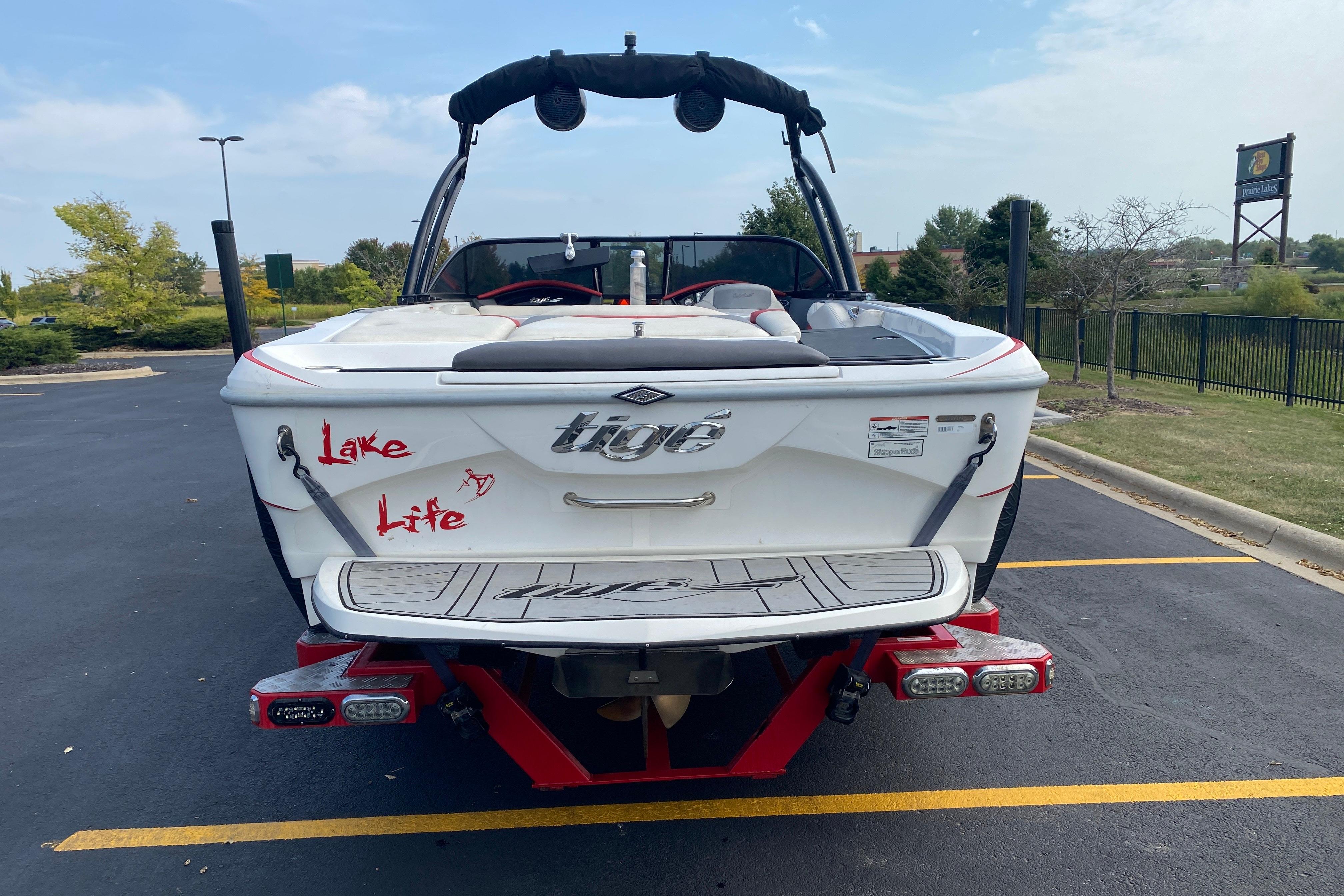 2014 Tigé R20 boat with "Lake Life" decal, parked in a lot.