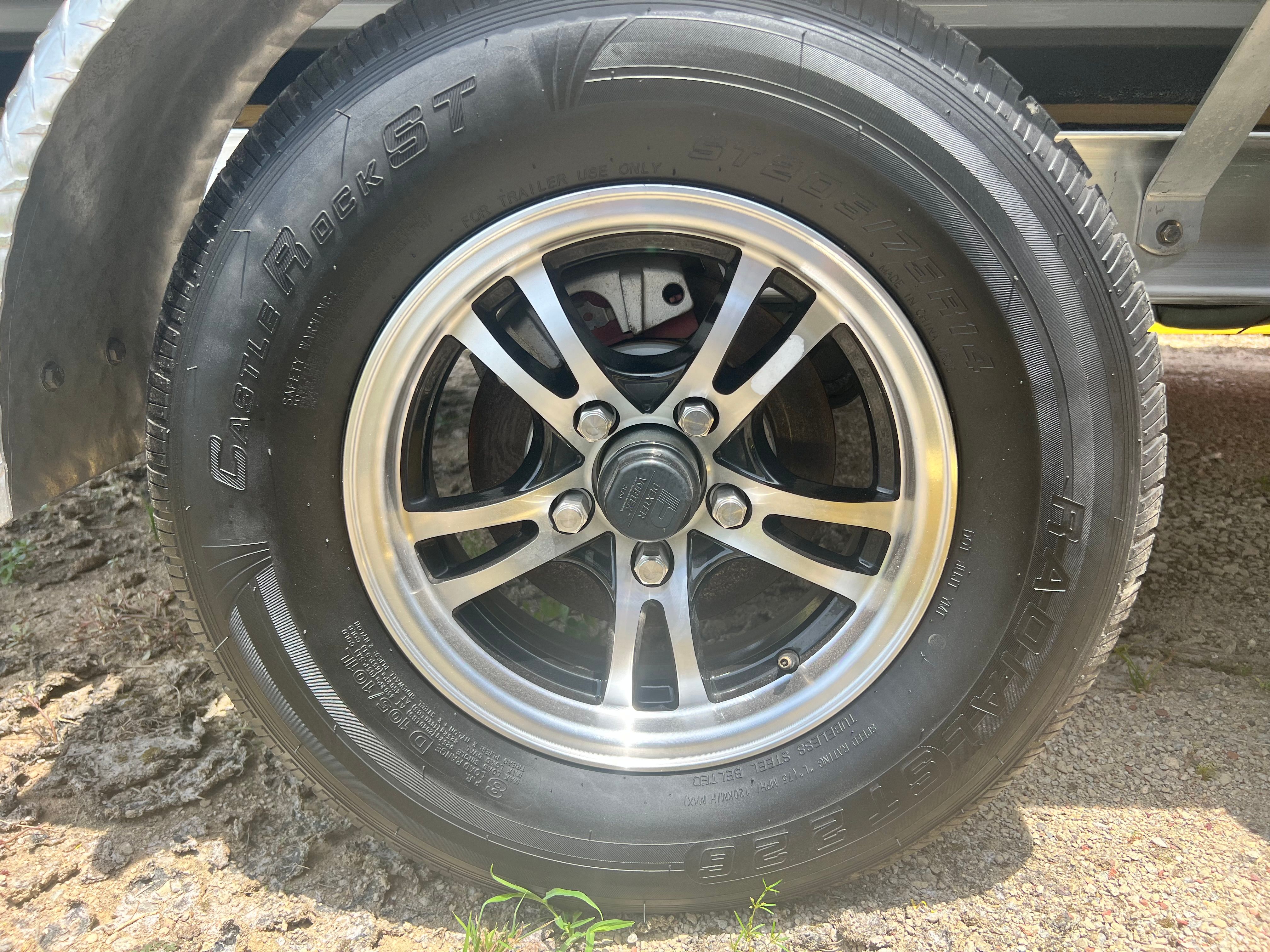 Close-up of a boat trailer wheel with a shiny rim and sturdy tire.
