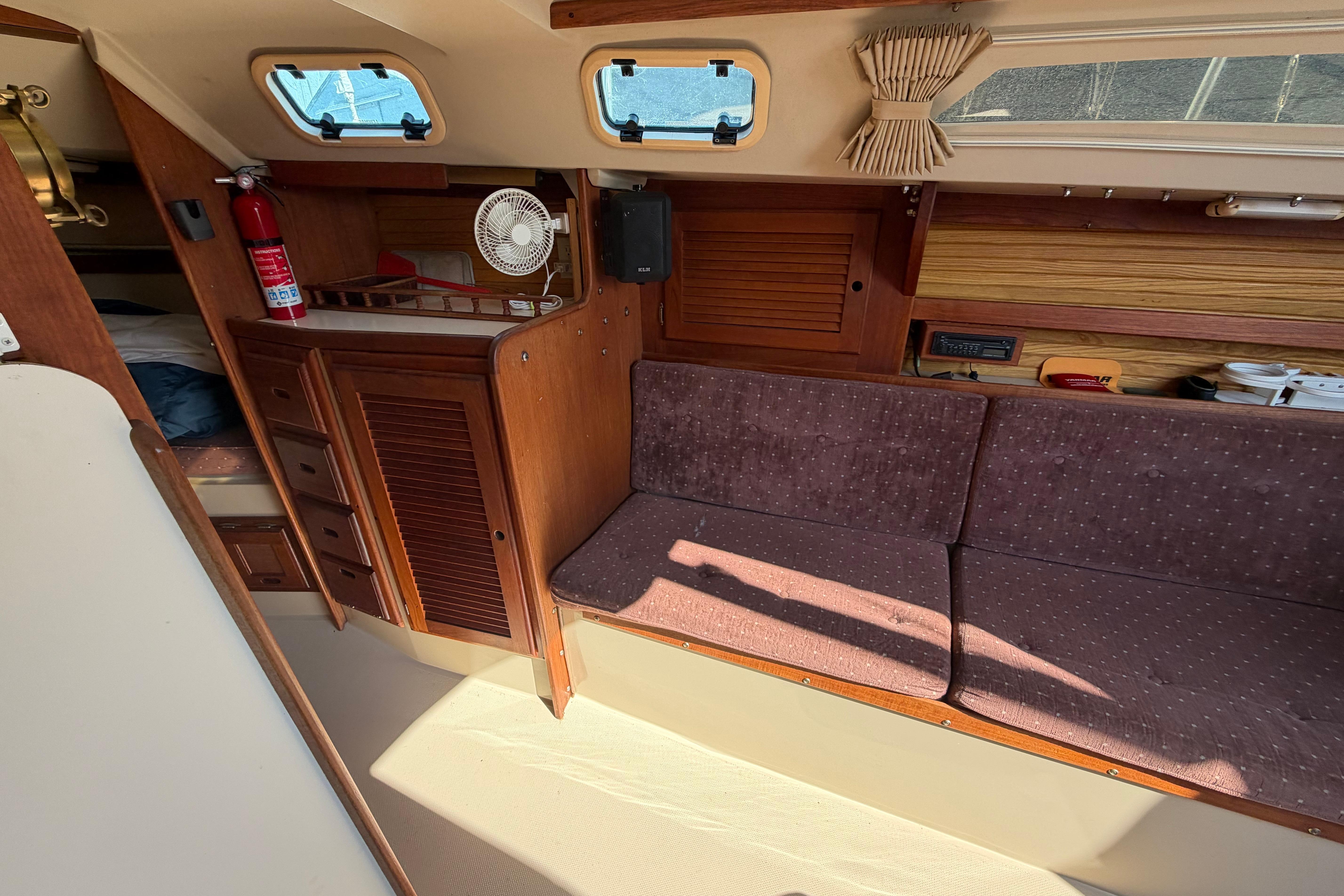 Interior of 1988 Catalina 30 MkII sailboat with wooden cabinetry and cushioned seating.