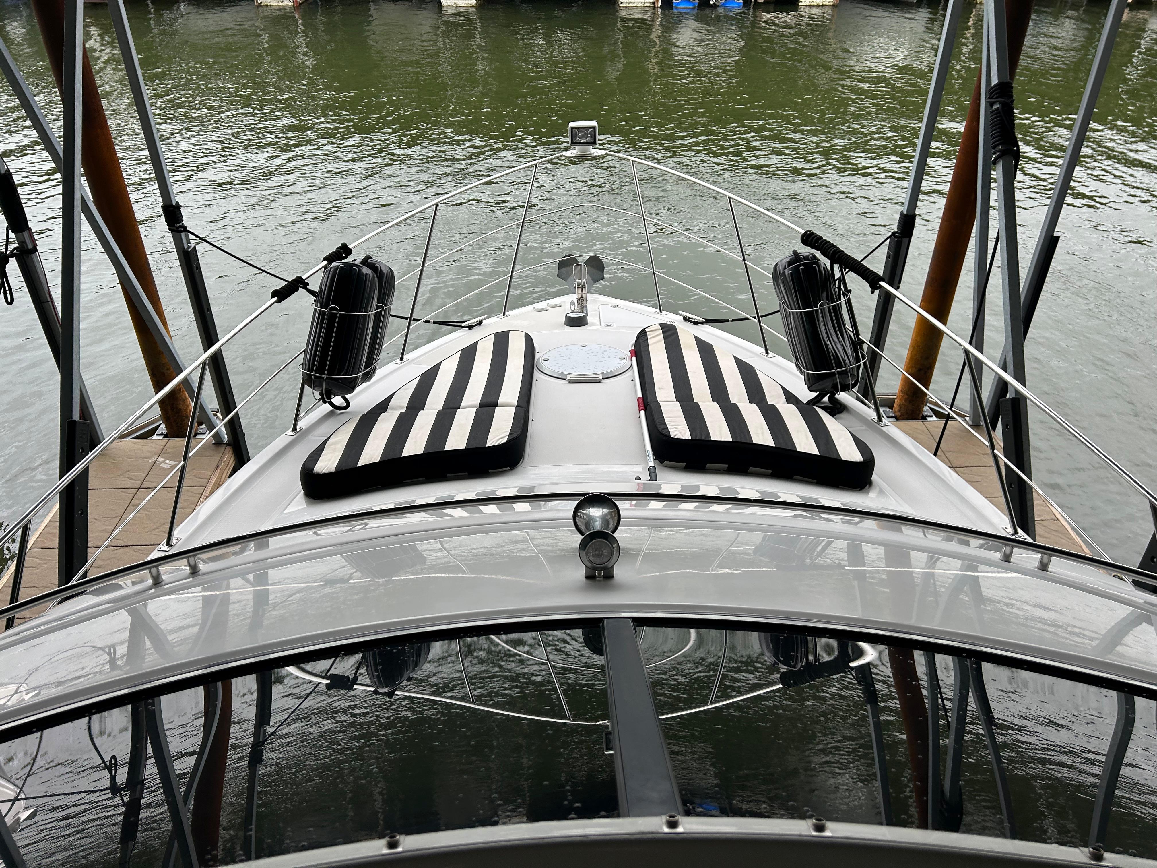 Carver 396 yacht from 2000 docked, featuring striped cushions on the deck.