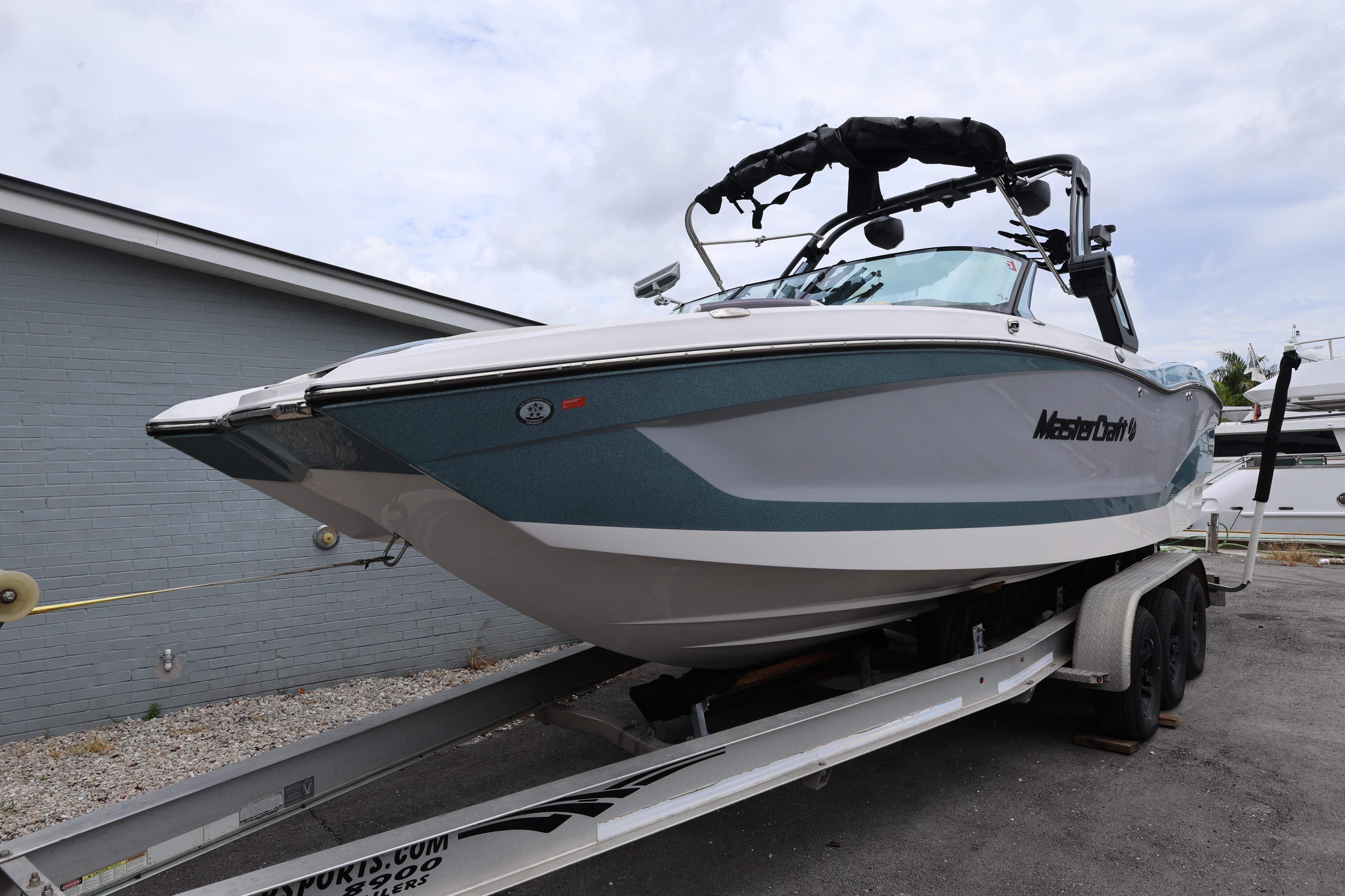 2023 MasterCraft X24 boat on trailer, parked outdoors.