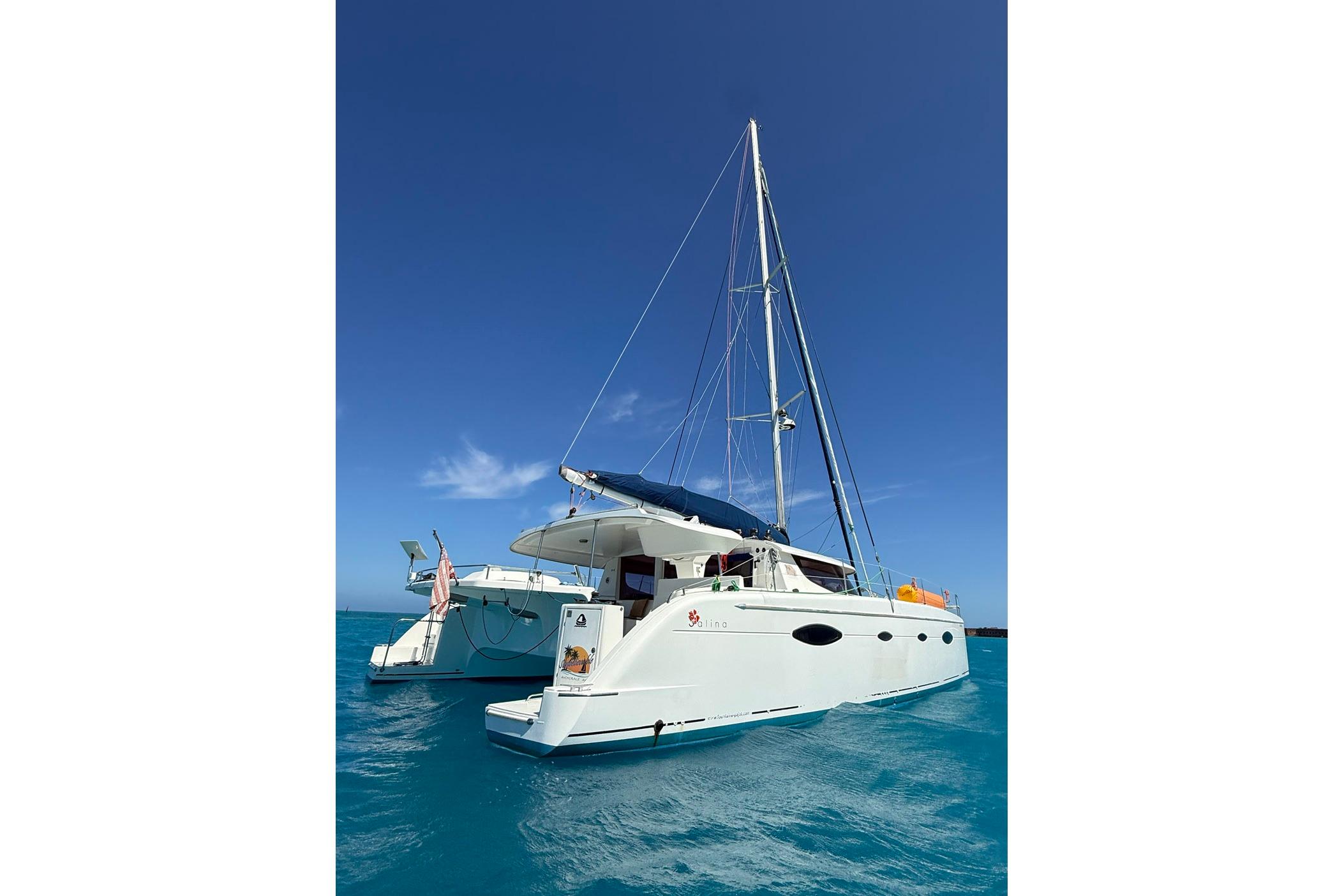 2008 Fountaine Pajot Salina 48 catamaran sailing on clear blue waters under a sunny sky.