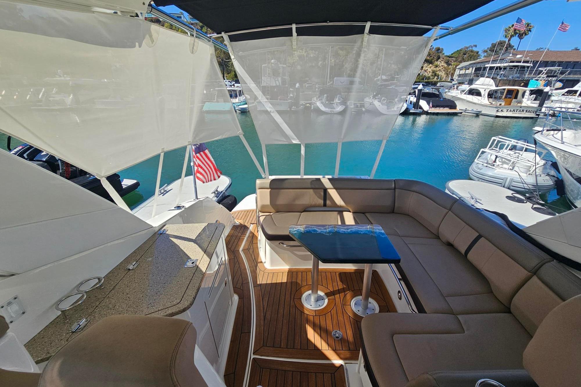 2016 Sea Ray Sundancer 350 yacht interior with seating, table, and marina view.