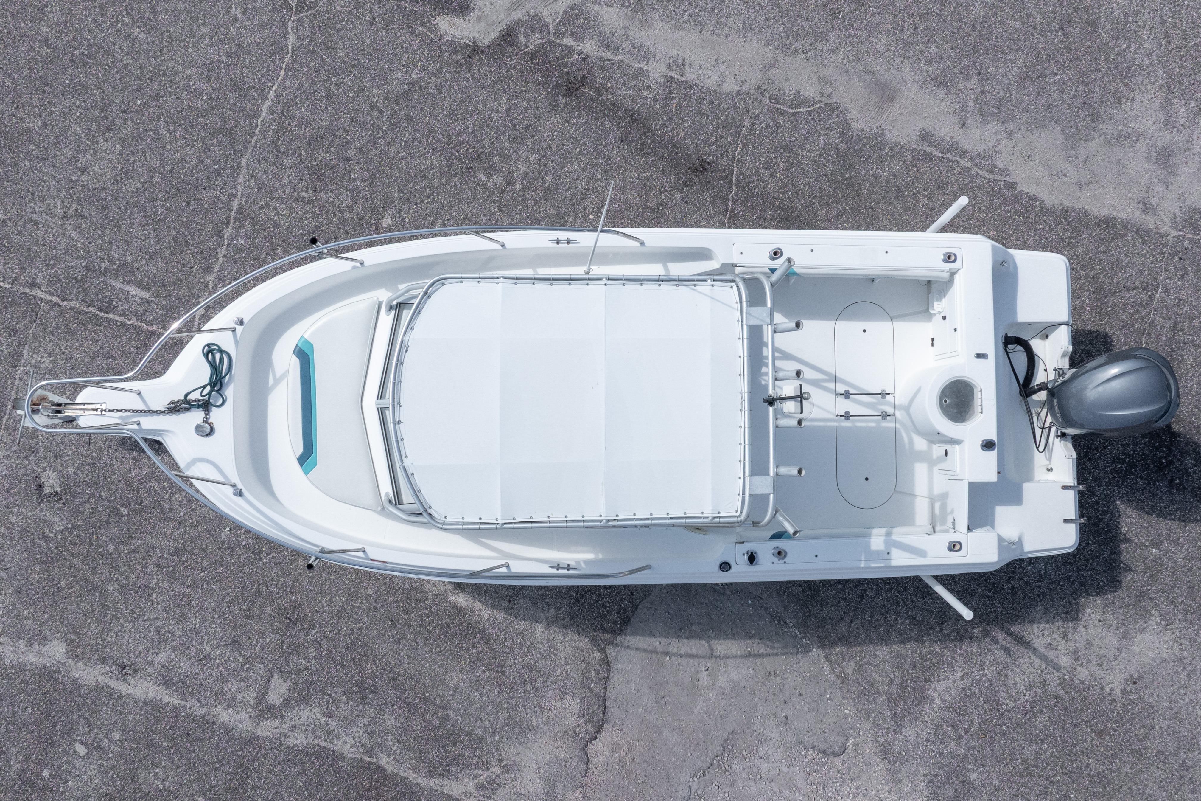 Overhead view of a 1999 Aquasport 225 Explorer boat on concrete surface.