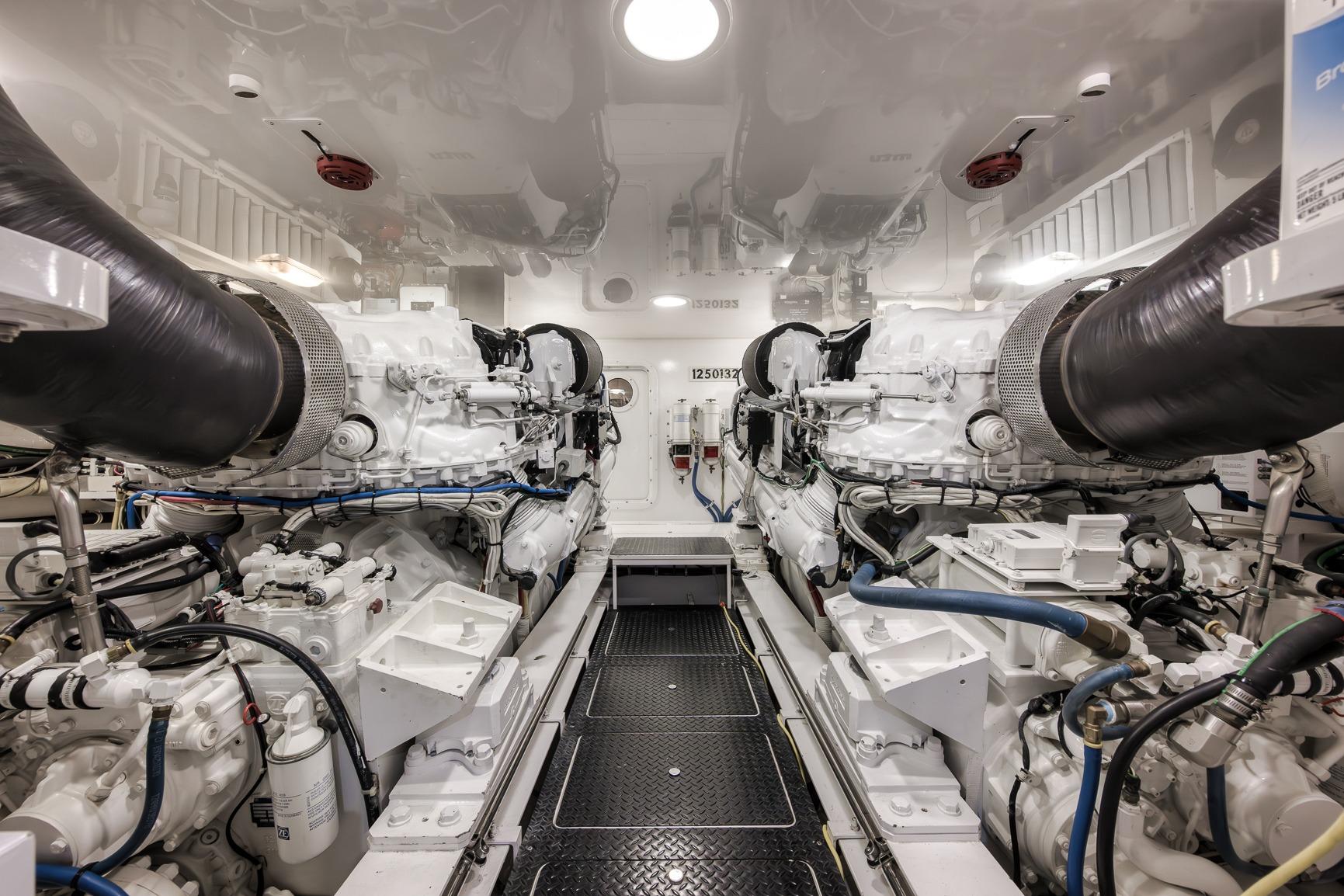 Engine room of 2012 Viking 70 Enclosed Bridge yacht, showcasing dual engines and mechanical systems.