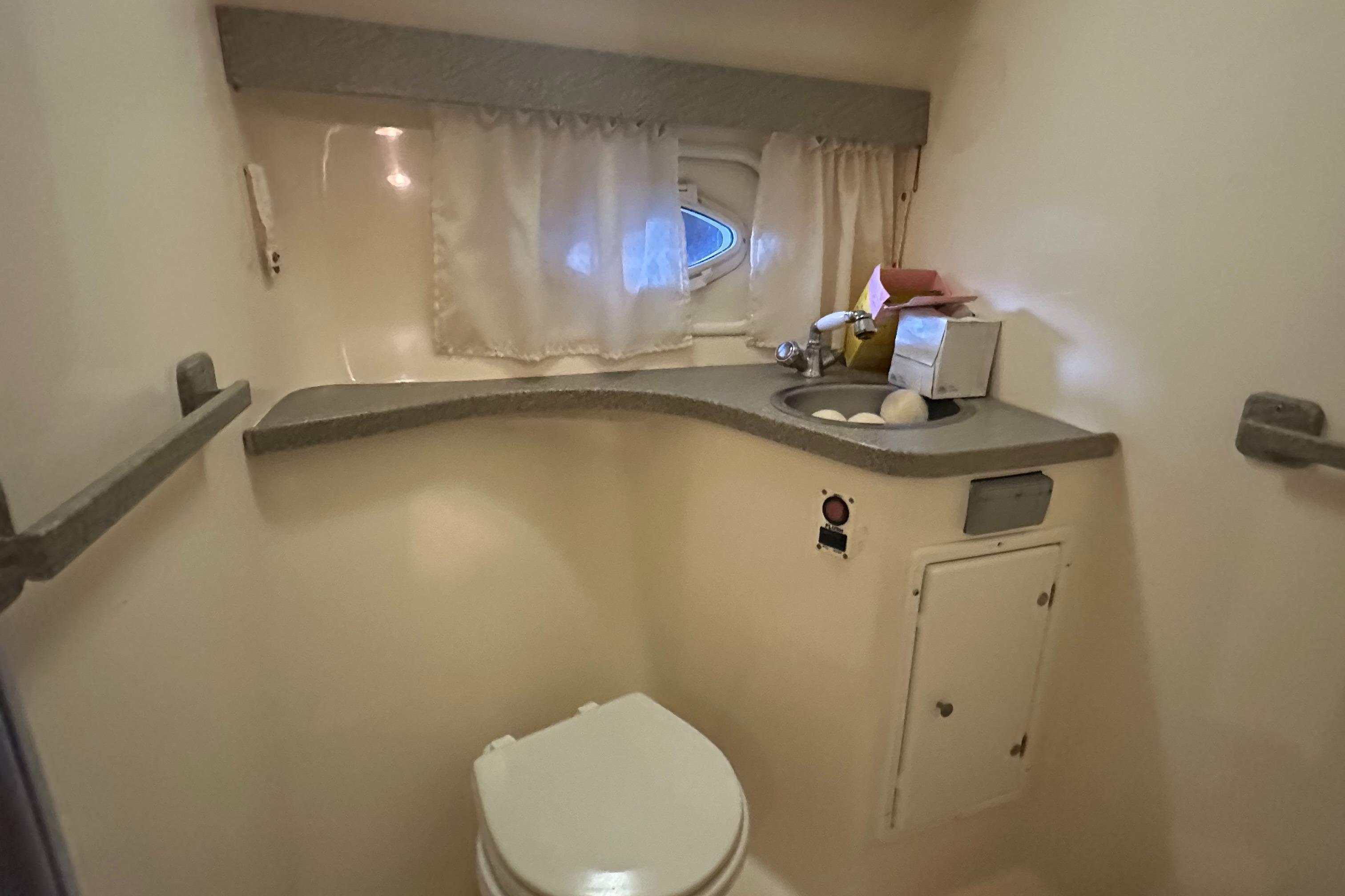 2003 Rinker Fiesta Vee 312 boat bathroom with sink and toilet.