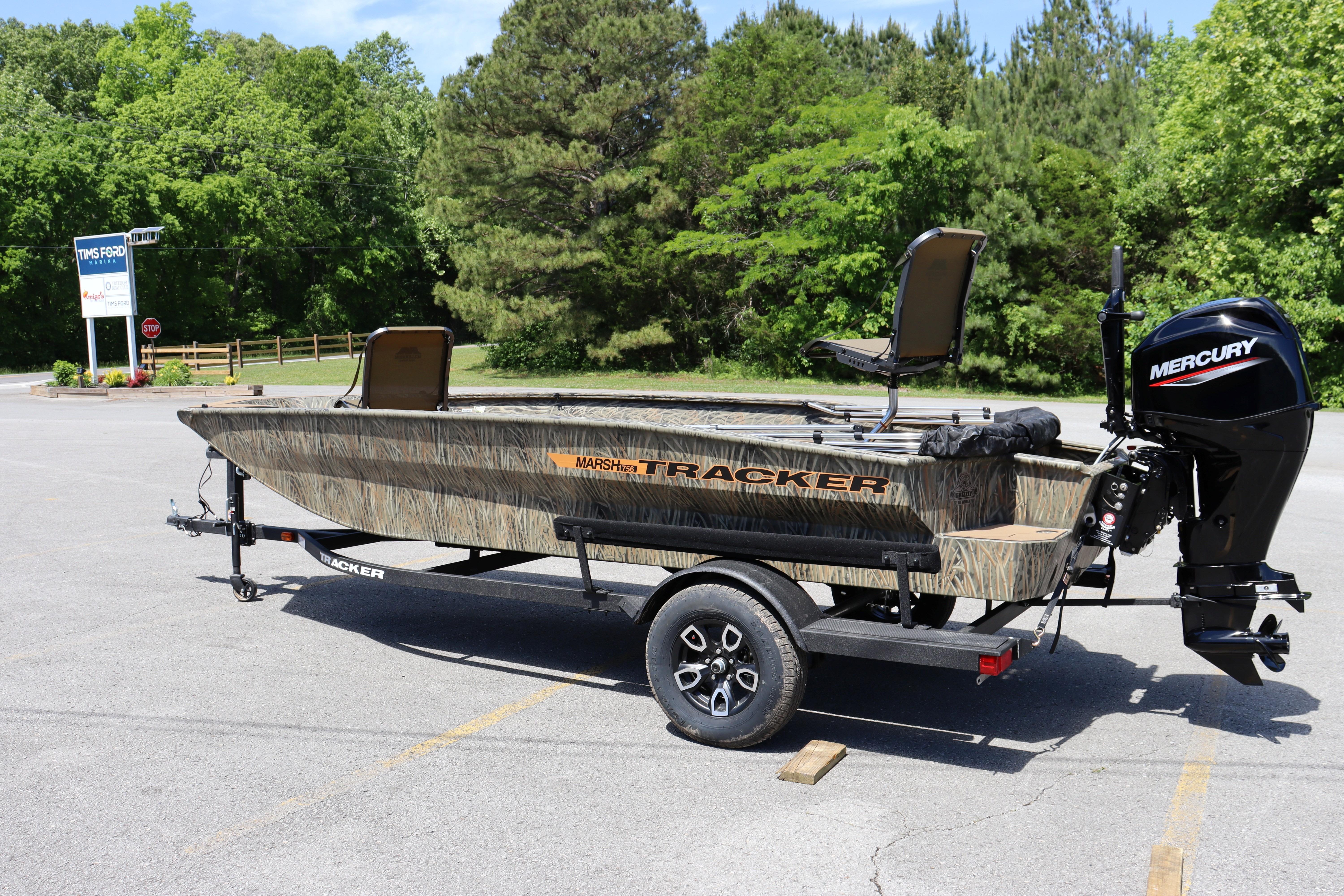 2026 Tracker Grizzly 1756 T Marsh boat with Mercury engine in a parking lot.