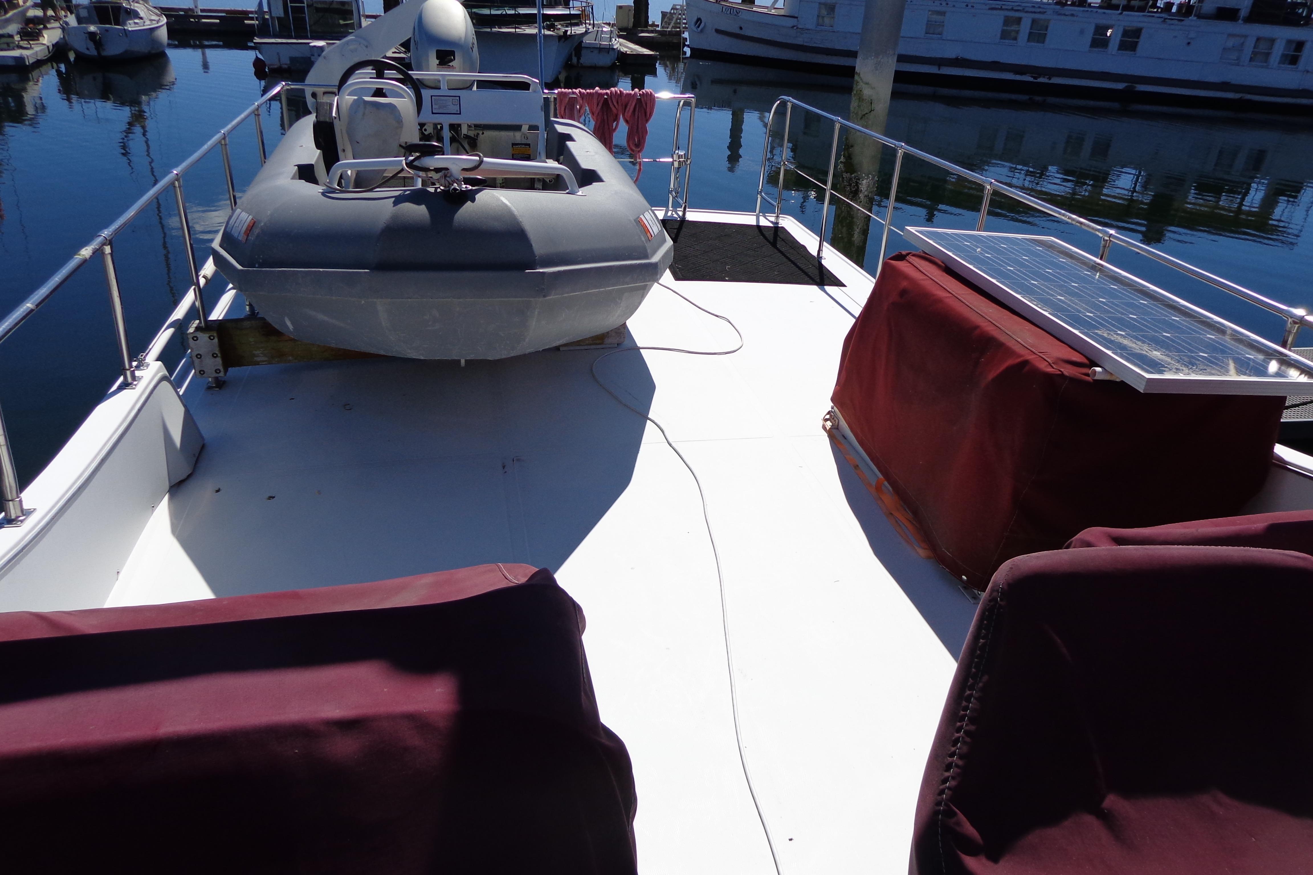 1992 Cruise-A-Home Corsair 4200 deck with dinghy and solar panel at marina.