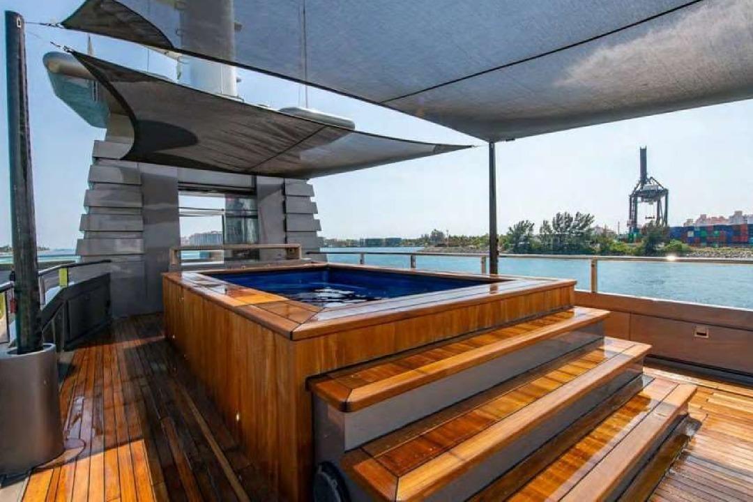 Luxurious Oceanfast 53 yacht deck with hot tub, 2004 model, overlooking serene waterfront.