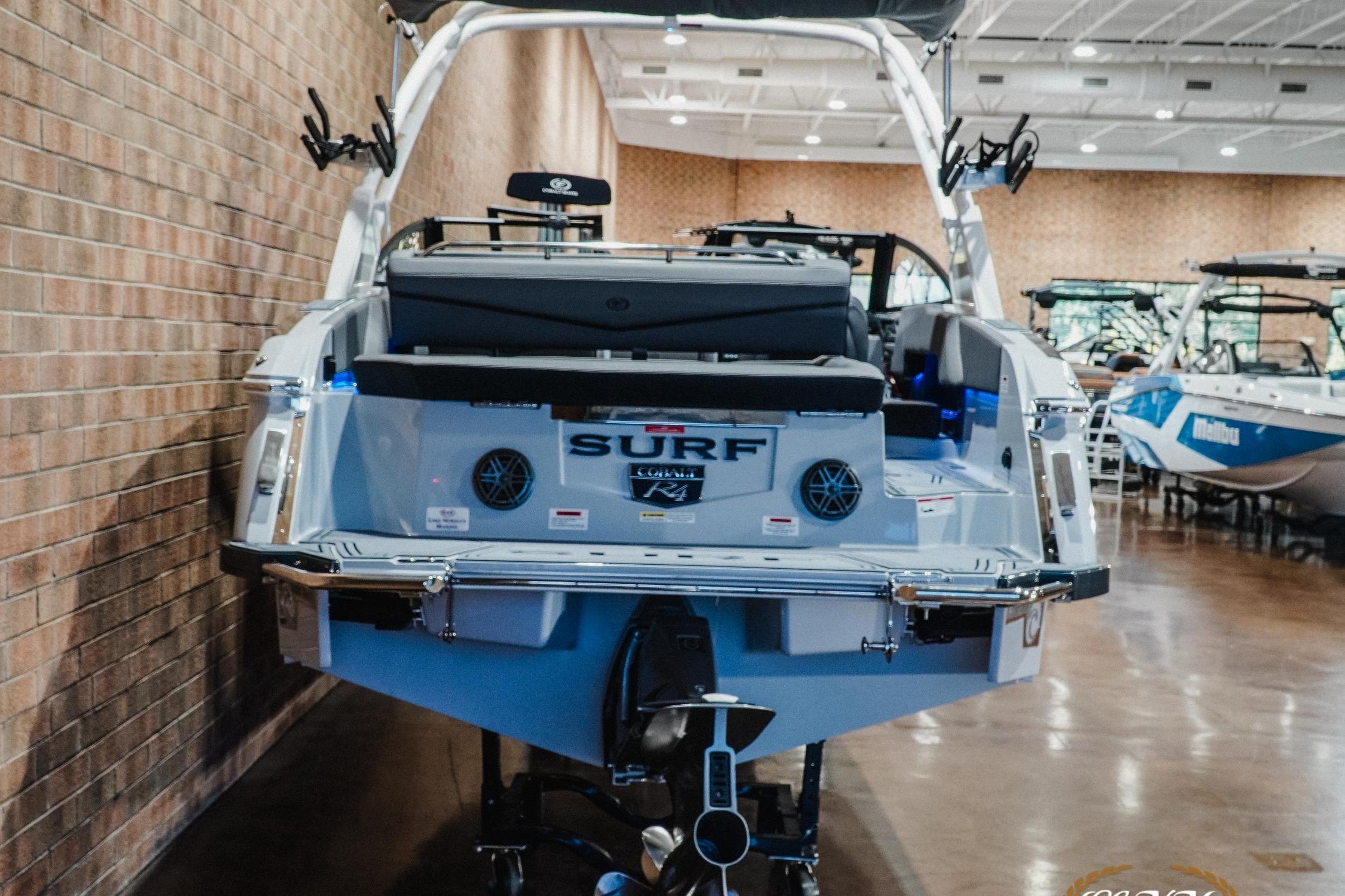 2026 Cobalt R4 Surf boat displayed indoors, showcasing rear design and features.