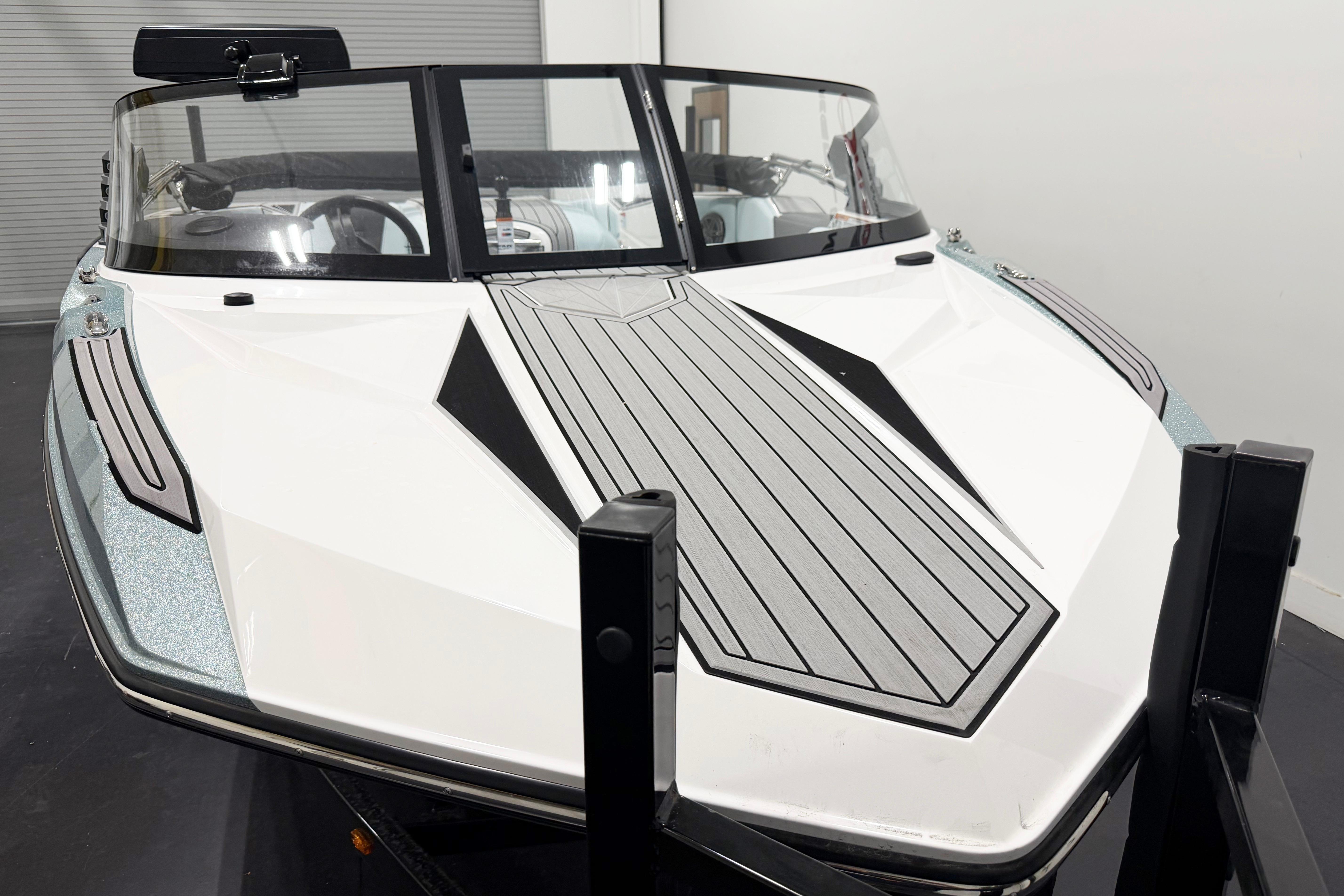2025 Nautique Ski Nautique boat with sleek design and modern features in a showroom setting.