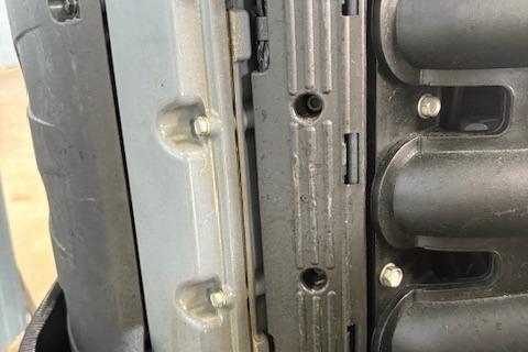 Close-up of a 2006 Intrepid 310 Walkaround engine component with visible bolts and metal casing.