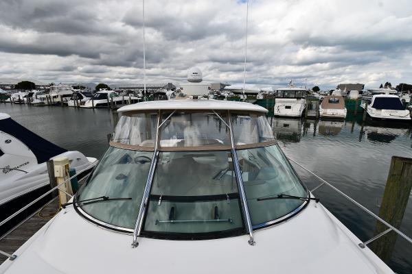 2003 Sea Ray 460 Sundancer yacht docked in a marina under cloudy skies.