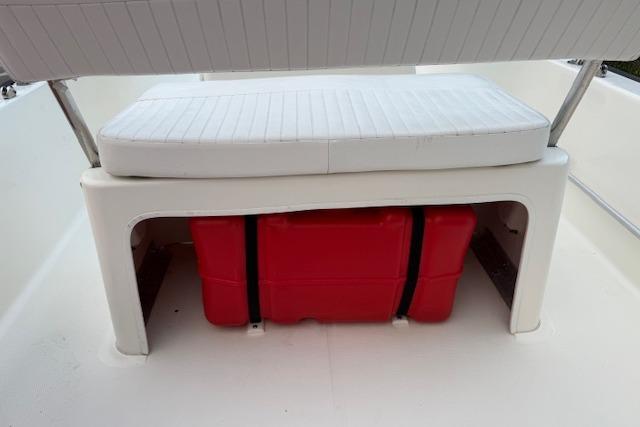 2016 Boston Whaler 150 Montauk boat seat with red storage container underneath.