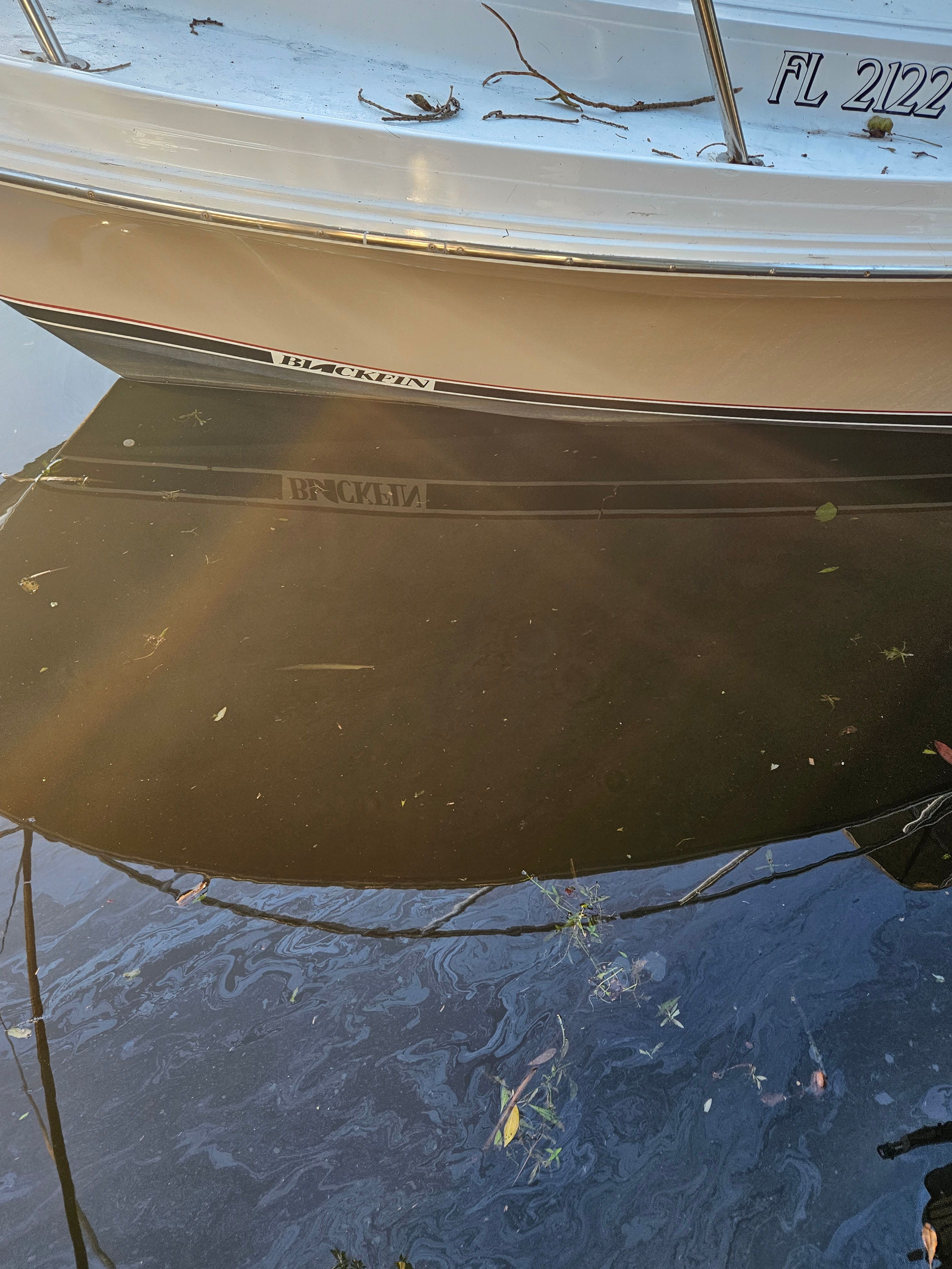 A boat named Blackfin is reflected in the water.