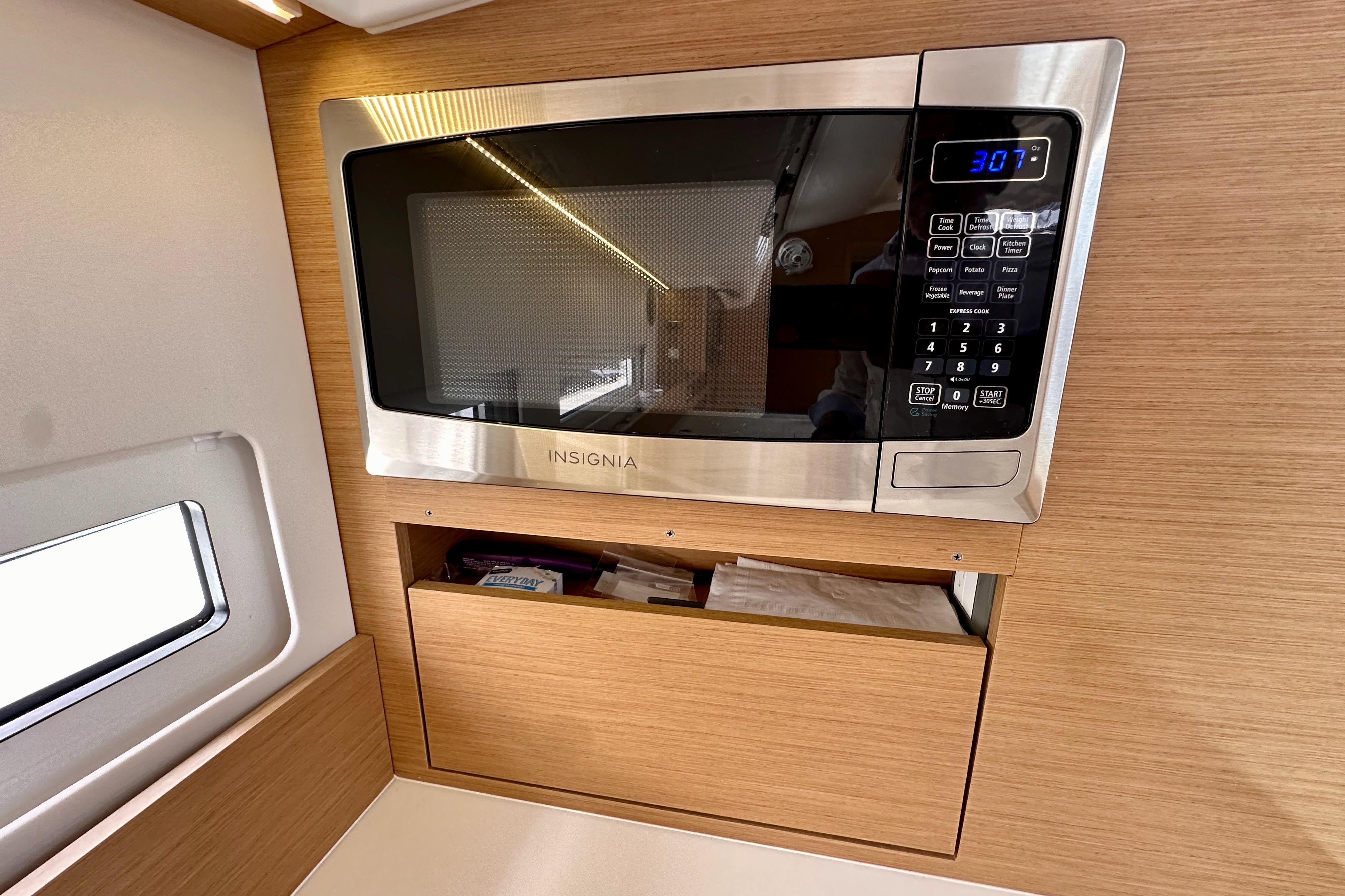 Microwave in 2024 Jeanneau Sun Odyssey 410 yacht kitchen, featuring modern wood cabinetry.