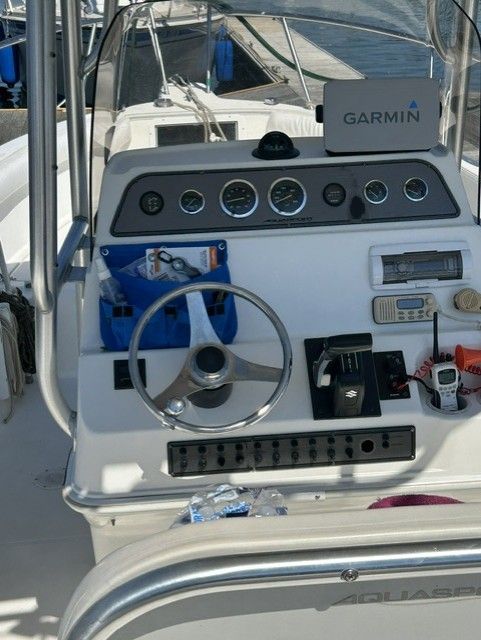 The image shows the helm of an Aquasport Osprey 250 boat with various instruments.