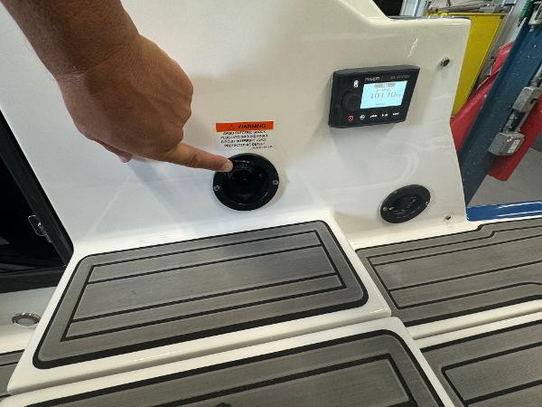 Close-up of a 2018 Monterey 258 Super Sport boat dashboard with a hand pointing at a control.