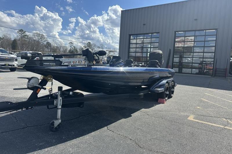 2020 Skeeter FXR21 boat on trailer outside a garage under a partly cloudy sky.