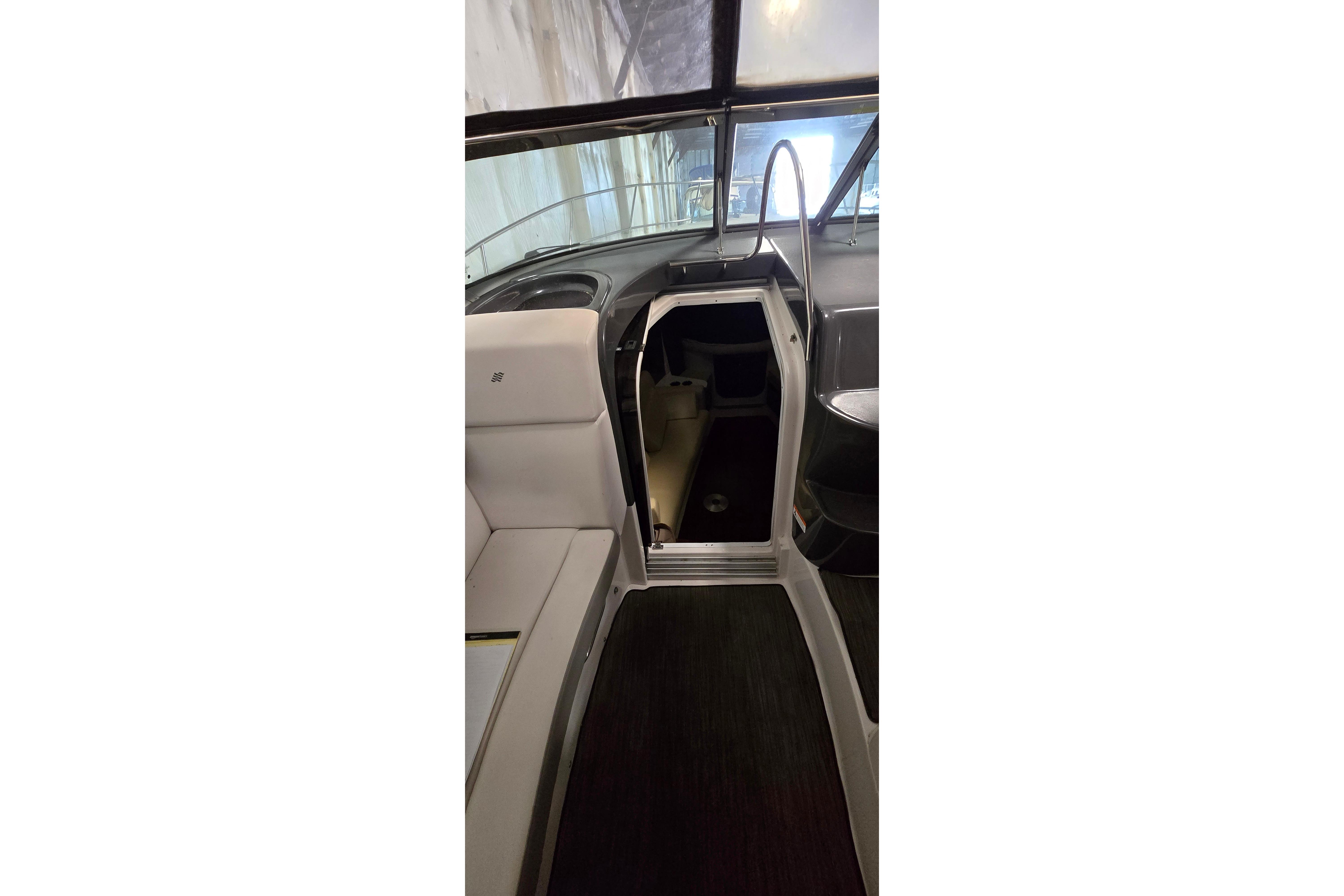 Interior view of 2018 Four Winns V355 boat, featuring seating and cabin entrance.